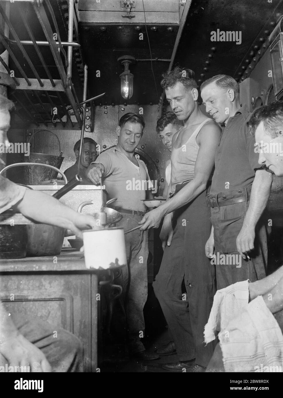 L'équipage du cuiseur à vapeur de tramp , ' Eston ' cuisant dans la cuisine du navire . 1935 Banque D'Images