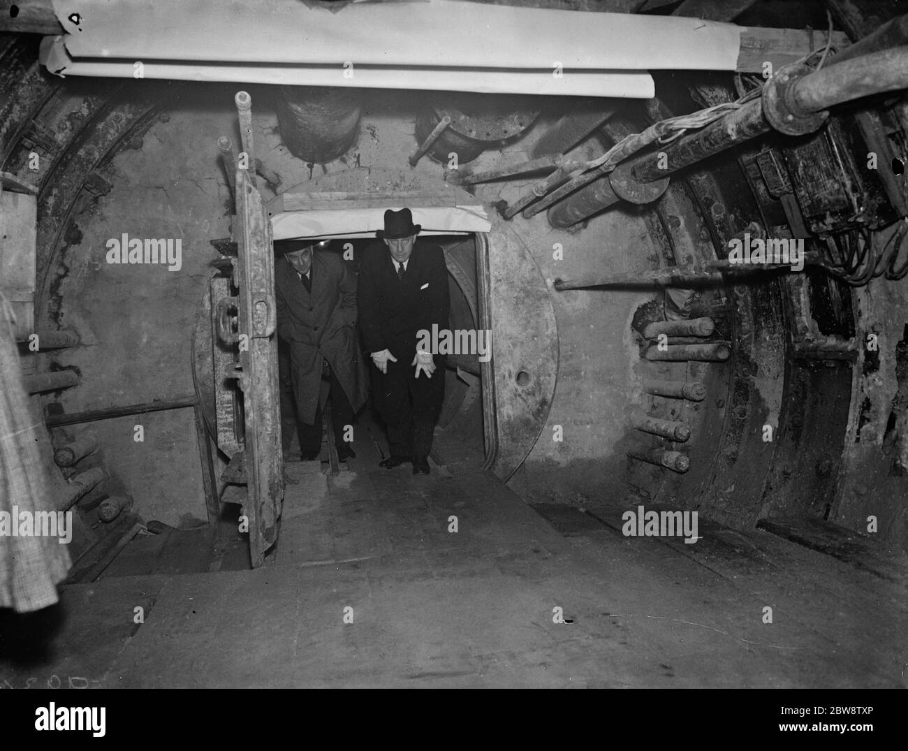 La construction du tunnel de Dartford , où un tunnel pilote a été récemment achevé . Le ministre des Transports , M. Leslie Burgin , qui sort d'une écluse aérienne , lors de sa visite au tunnel de Dartford . 1938 1938 Banque D'Images