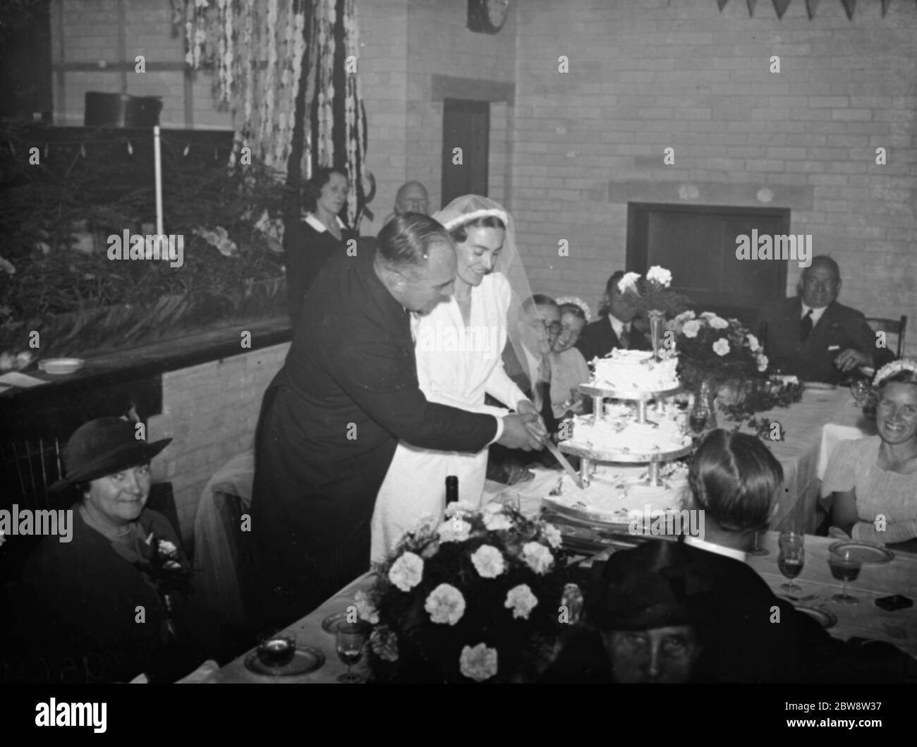 Le mariage de M. John Topham et de Mlle Muriel Haken . Les jeunes mariés ont coupé le gâteau au petit déjeuner de mariage. 1938 Banque D'Images