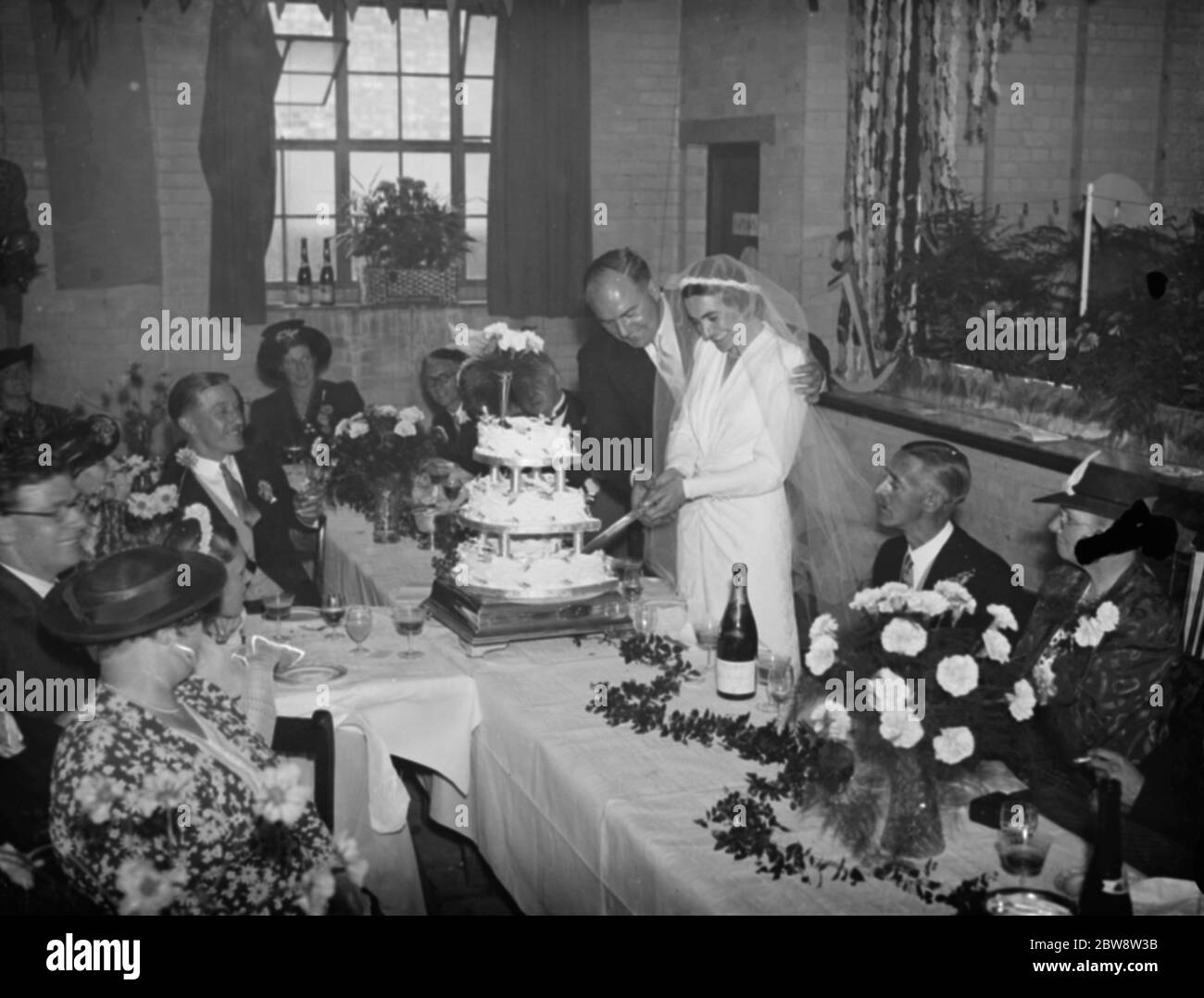 Le mariage de M. John Topham et de Mlle Muriel Haken . Les jeunes mariés ont coupé le gâteau au petit déjeuner de mariage. 1938 Banque D'Images