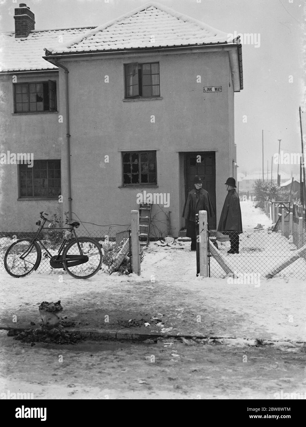 Deux policiers se tiennent devant une maison , le site d'une tragédie des incendies à Bromley , dans le Kent . 23 novembre 1938 Banque D'Images