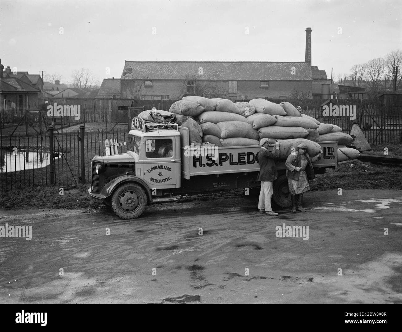 Les travailleurs déchargent des sacs d'un camion Bedford appartenant à la société de broyage de nantissement & son Ltd , lors d'une de leurs livraisons à Ashford , dans le Kent . 1939 Banque D'Images