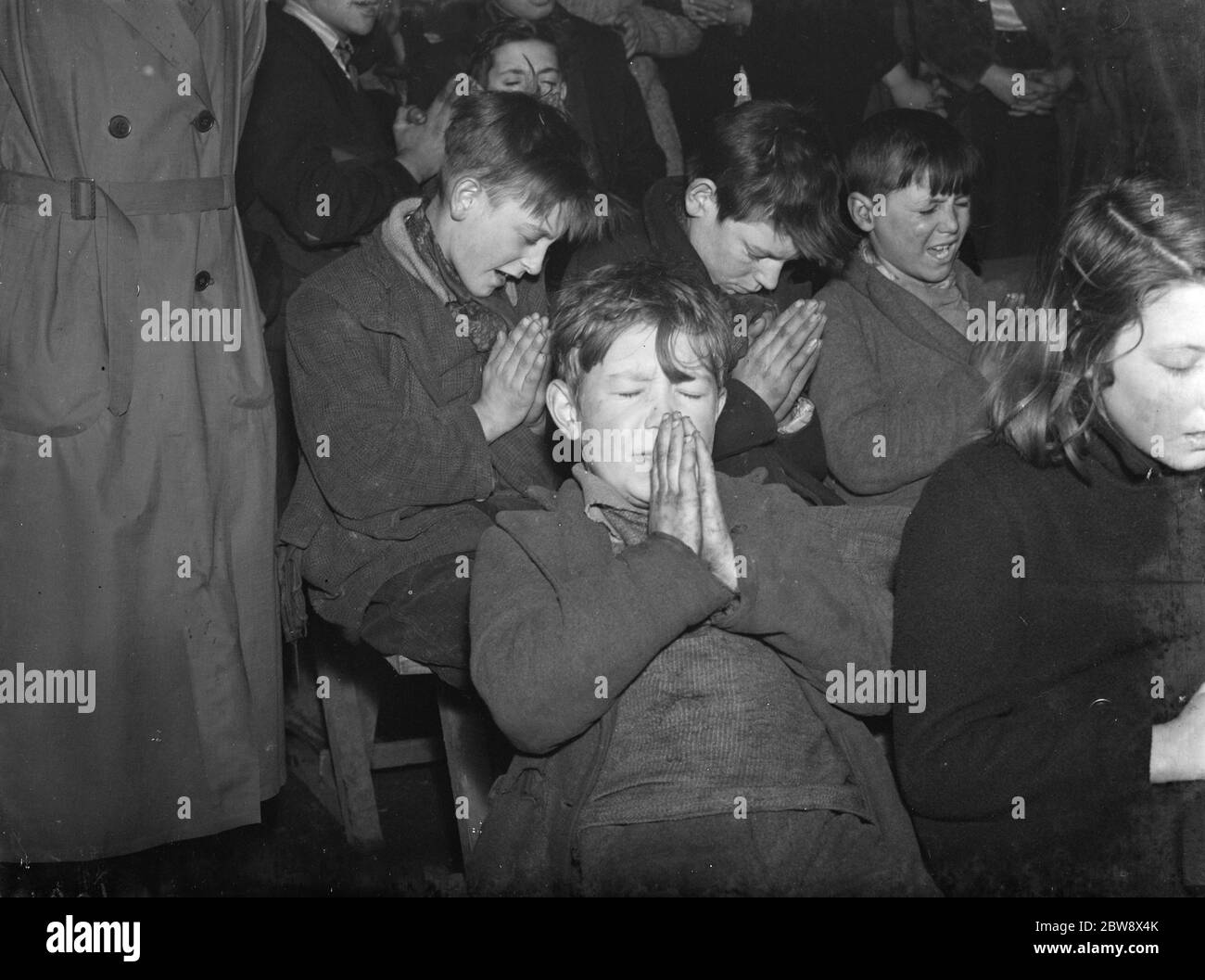 École de dimanche des enfants tziganes dans le hangar à vaches de St Mary Cray . Les enfants priant . 1939 Banque D'Images