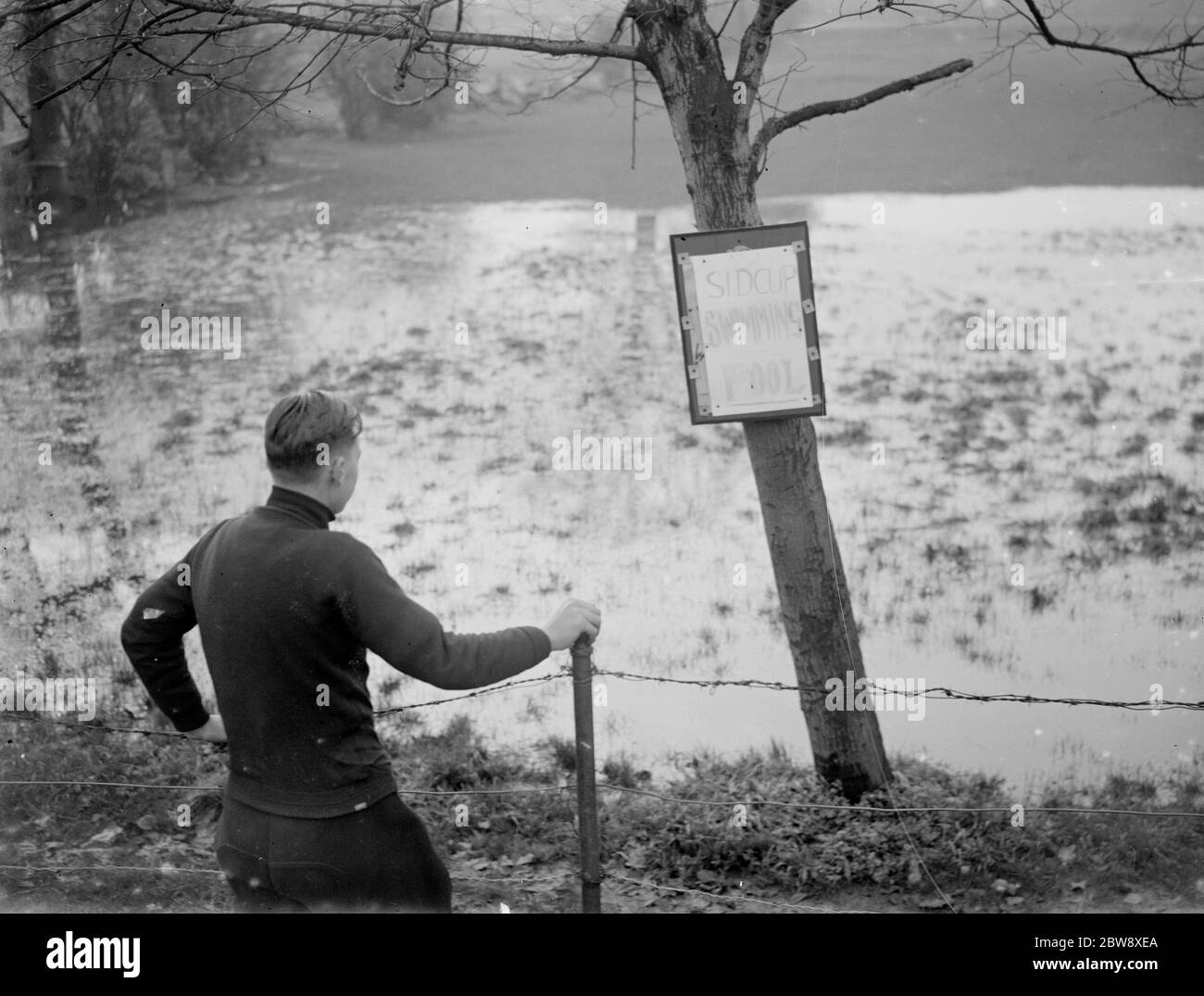 Un garçon regarde la piscine Sidcup inondée - inondée en raison du mauvais temps. 1936 Banque D'Images