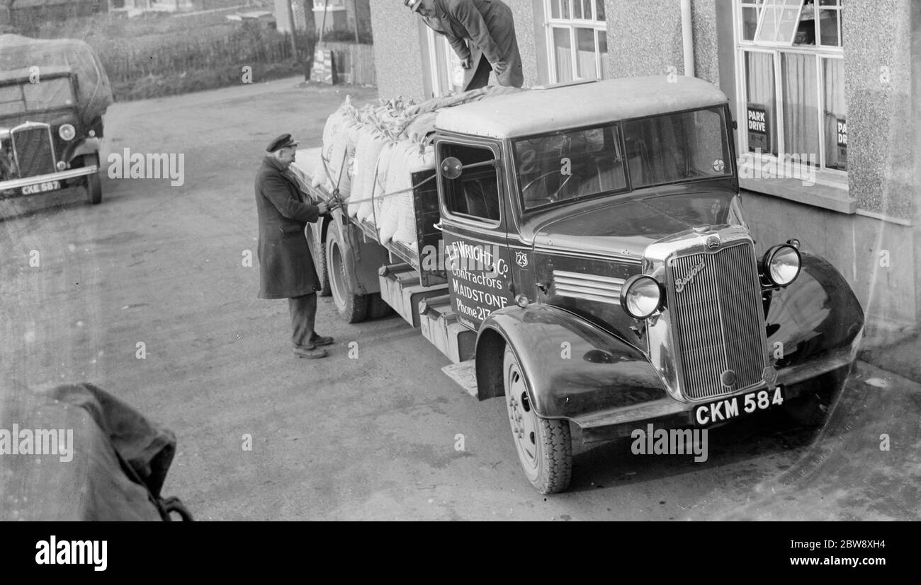 Des hommes chargent des sacs sur un camion L E Wrights and Company Bedford . 1936 Banque D'Images