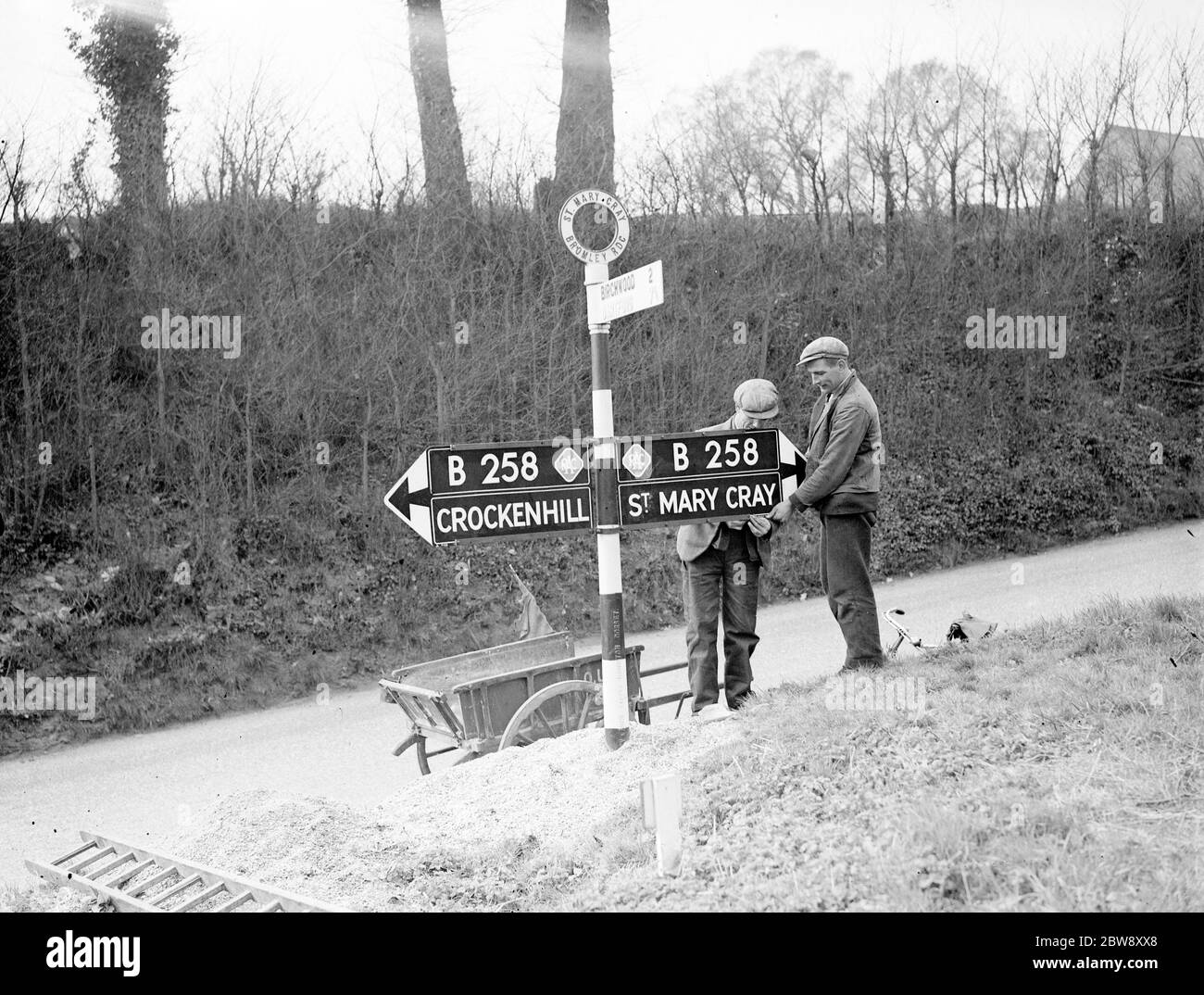 Ouvriers mettant un panneau de route secondaire RAC sur le B258 . 1938 Banque D'Images