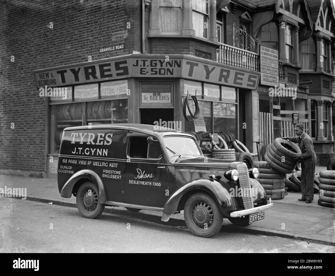 Un magasin J T Gynn et son Tires avec leur camion Bedford stationné à l'extérieur , à Bexleyheath , dans le Kent . Un homme charge la camionnette avec des pneus . 1938 Banque D'Images