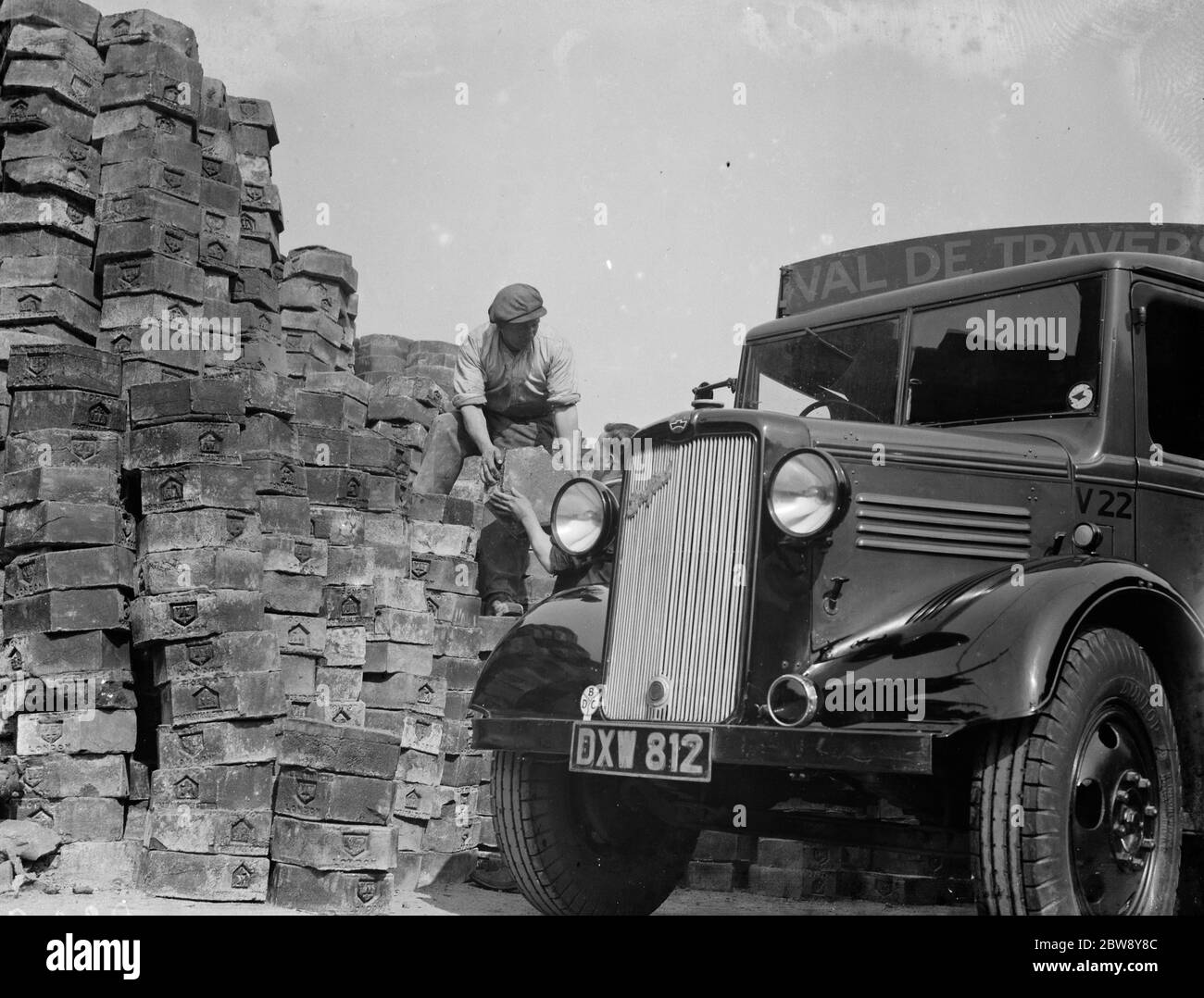 Les ouvriers chargent un camion Bedford avec des blocs d'asphalte . 1938 Banque D'Images