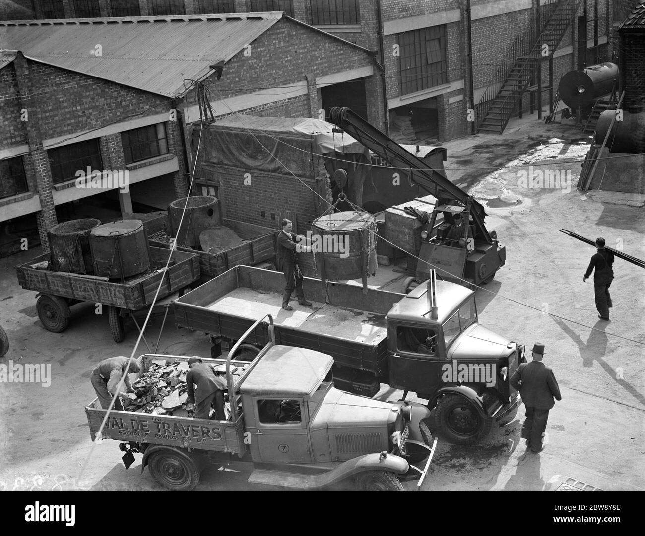 Travailleurs utilisant une grue pour charger un camion Val de travers Bedford avec des chauffages . 1938 Banque D'Images