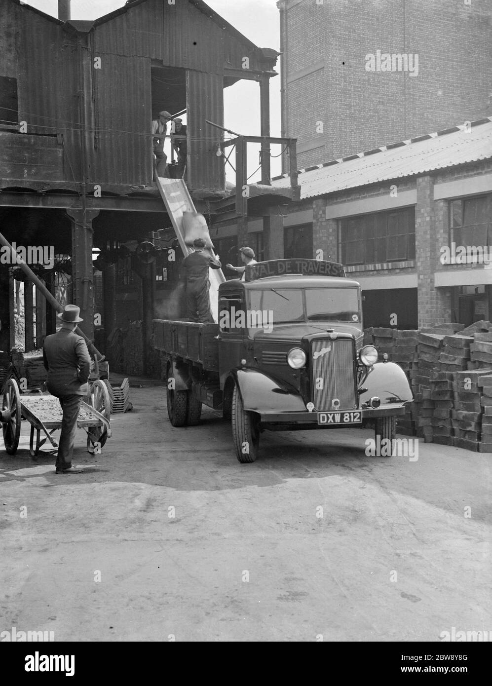 Les travailleurs qui utilisent une lame pour charger un camion de Val de travers Bedford . 1938 Banque D'Images