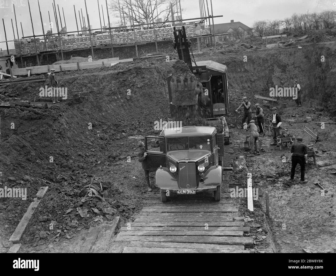 Digger débarrade la terre et met le sol à l'arrière du camion Bedford sur le site de la nouvelle piscine Bexleyheath à Bexleyheath , Kent . 1936 Banque D'Images