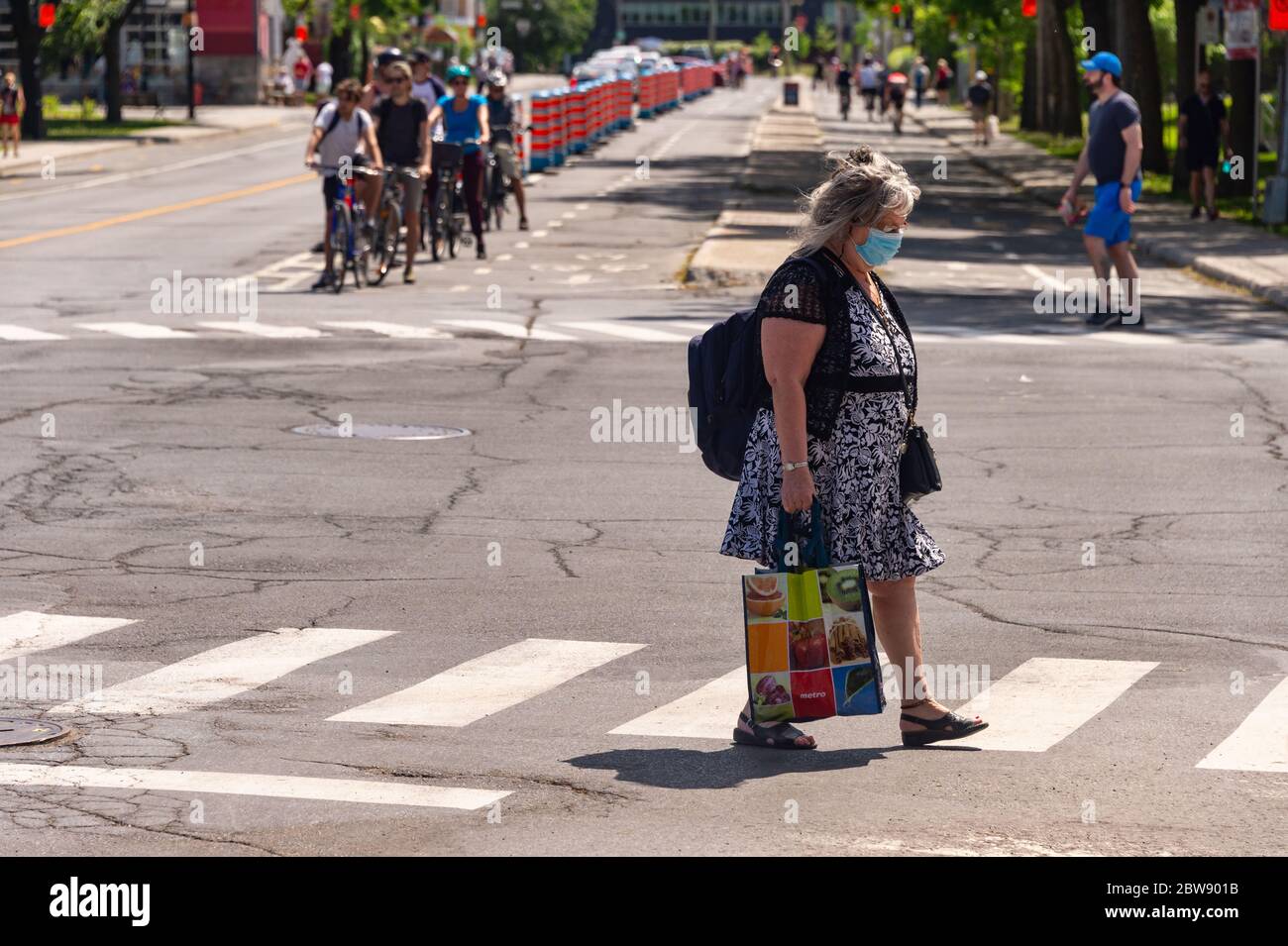 Montréal, CA - 30 mai 2020 : femme sénior avec masque facial pour la protection contre COVID-19, rue Rachel Banque D'Images