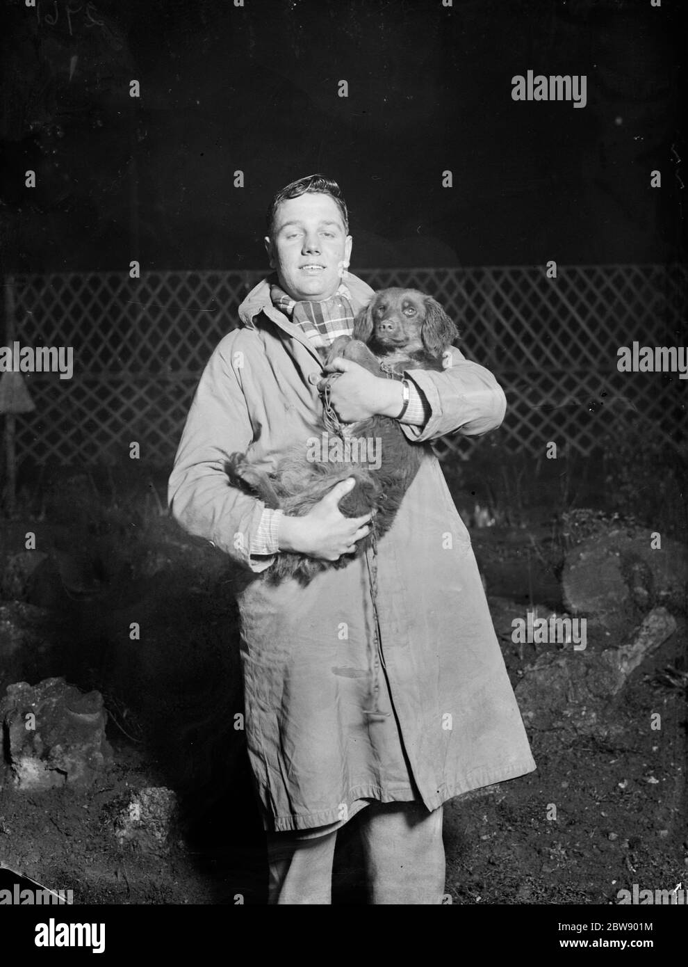 George Carlow tient aloft un chien sauvé . 1936 Banque D'Images