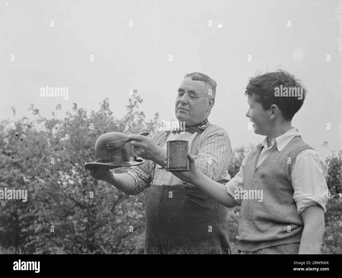 M. Charlie Hever peint du goudron sur un chapeau de lanceur à Eynsford , Kent . 1937 Banque D'Images
