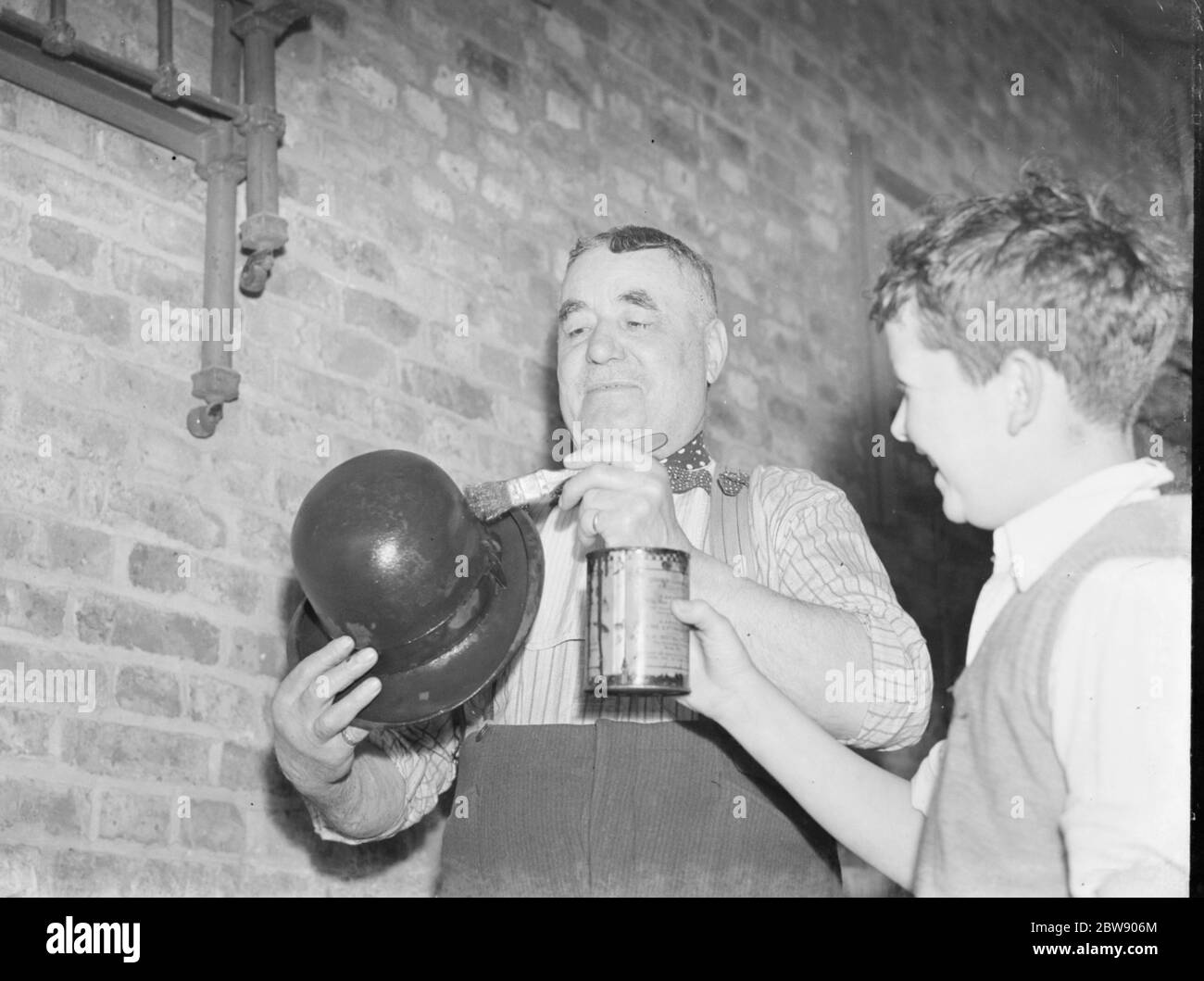 M. Charlie Hever peint du goudron sur un chapeau de lanceur à Eynsford , Kent . 1937 Banque D'Images