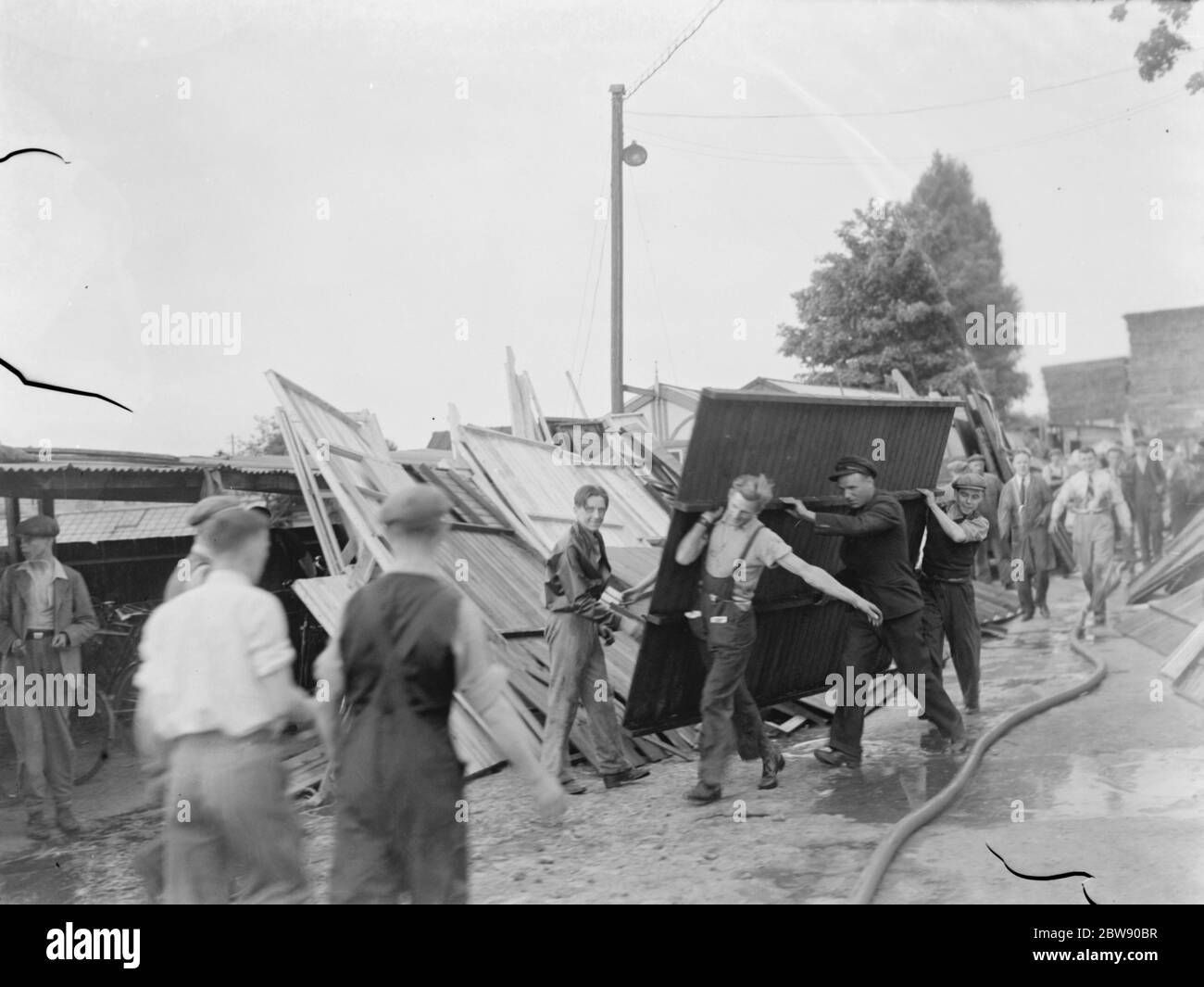 Les locaux aident à la mise en place suite au feu de chantier à Bexleyheath , Kent . 30 mai 1937 Banque D'Images
