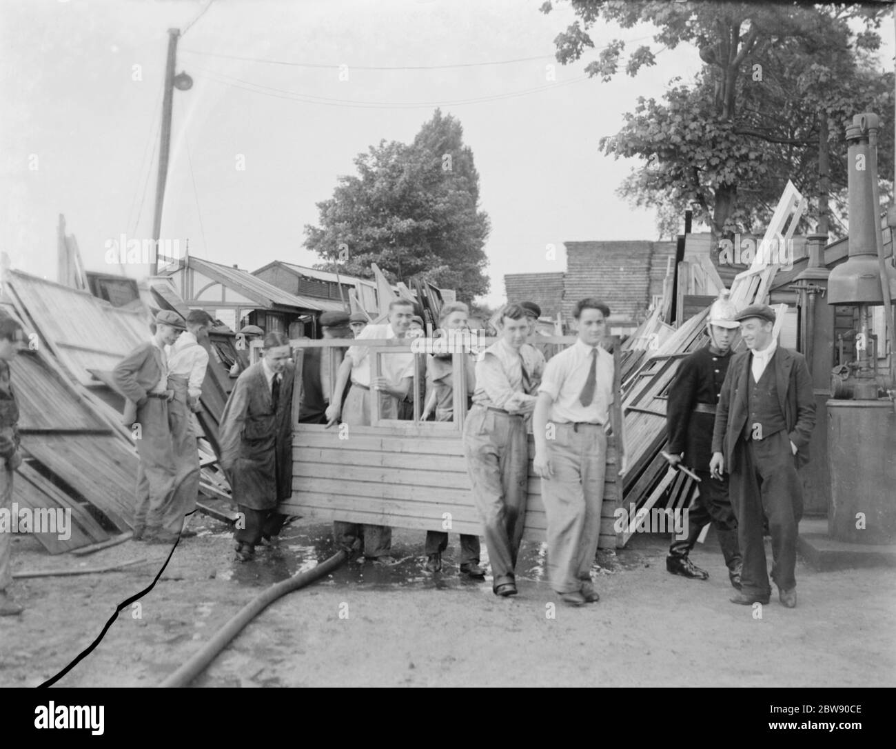 Les locaux aident à la mise en place suite au feu de chantier à Bexleyheath , Kent . 30 mai 1937 Banque D'Images