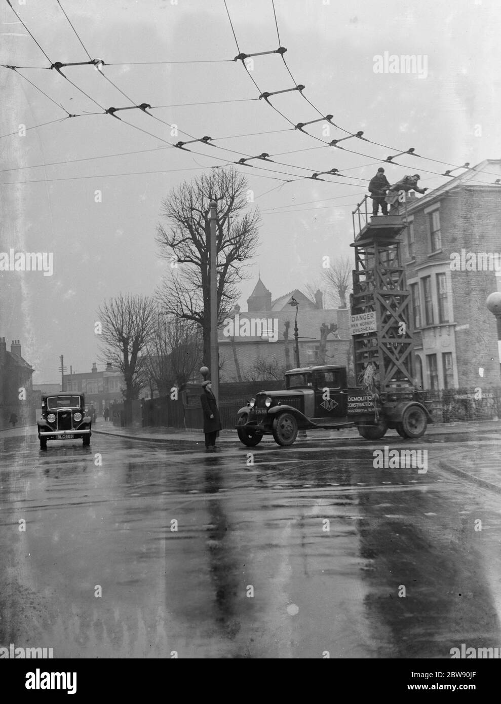 Les travailleurs de la Demolition and Construction Company Ltd utilisent leur chariot de la tour de tramway Bedford pour travailler sur les câbles électriques du trolleybus aérien . 1937 . Banque D'Images