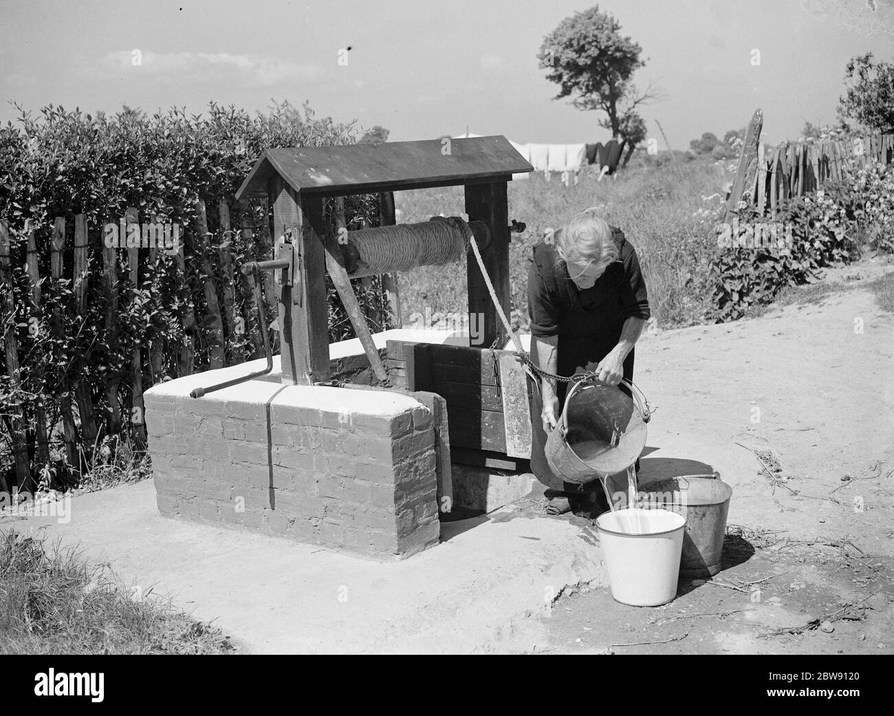 Rebecca Munday utilisant un puits d'eau dans Deans Bottom , Kent . 1939 . Banque D'Images
