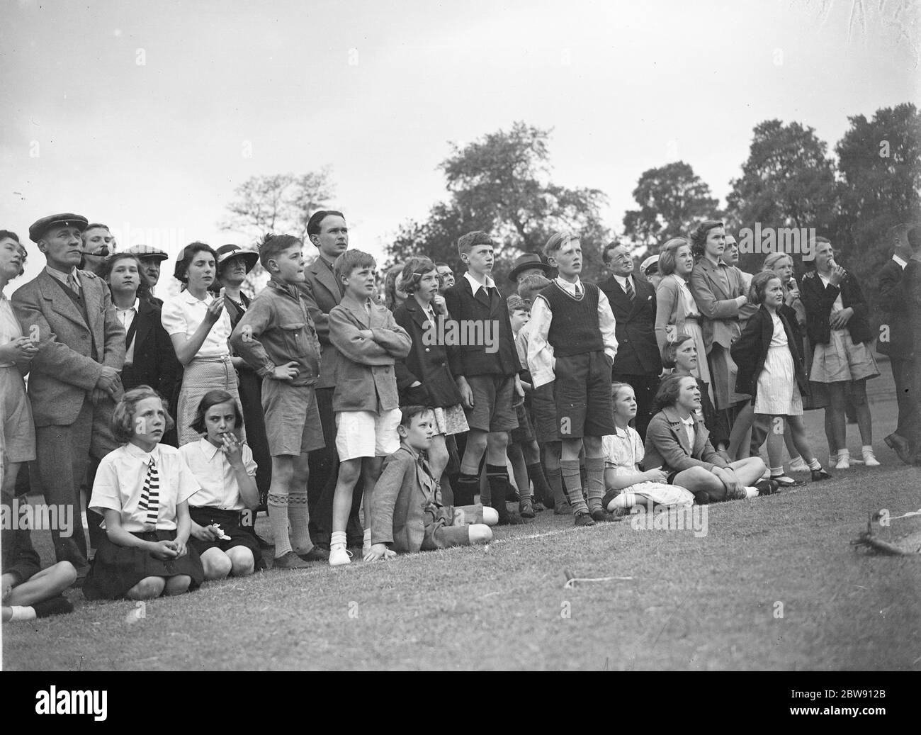 La foule regardant un artiste trapèze se jouer à la coupe de Sidcup dans le Kent . 1939 Banque D'Images