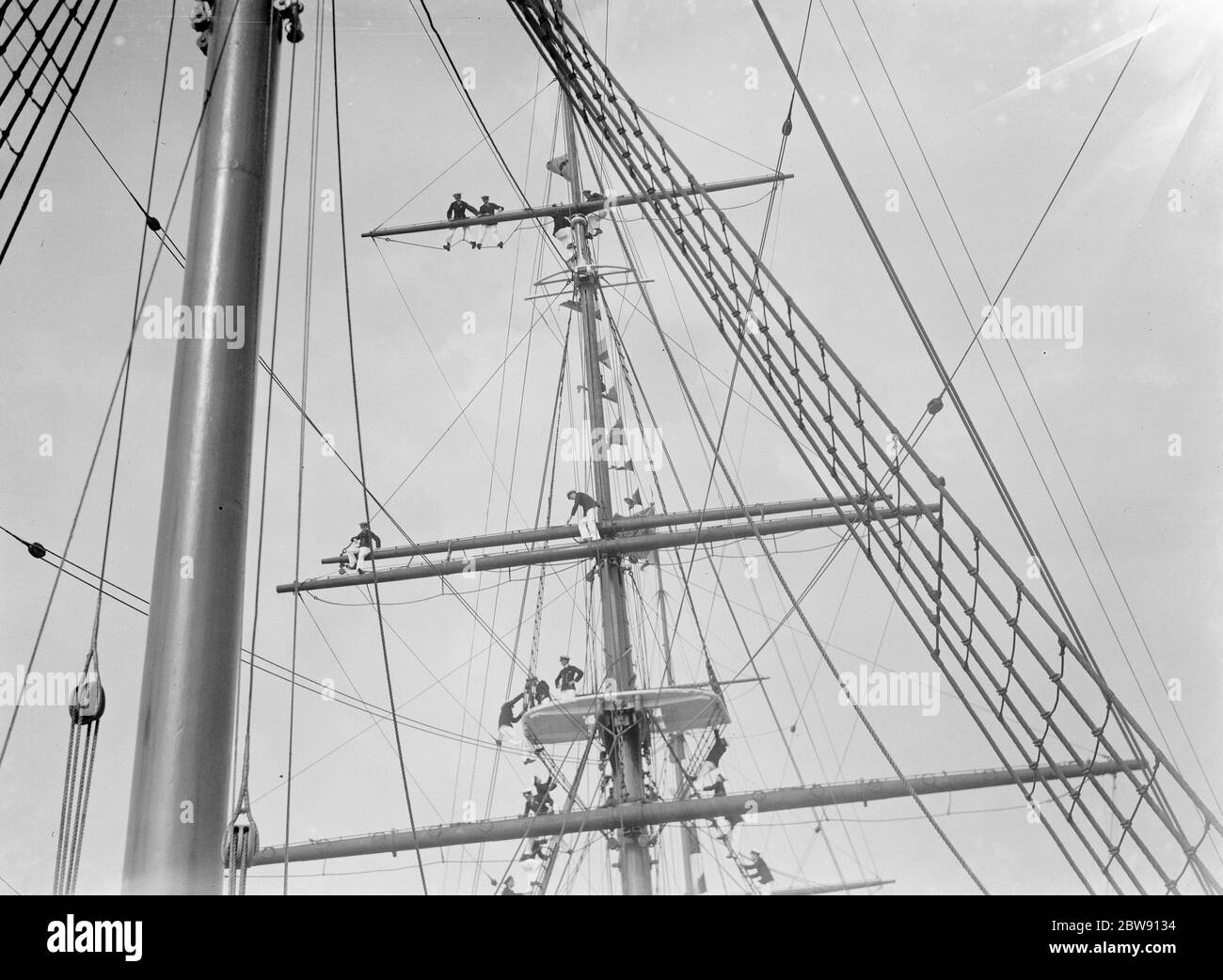 Les cadets du Thames Nautical Training College de Greenhithe , Kent , se tiennent sur le gréement du navire d'entraînement HMS Worcester . Ils essaient d'obtenir une meilleure vue de la course de bateaux de formation de Worcester . 1937 Banque D'Images