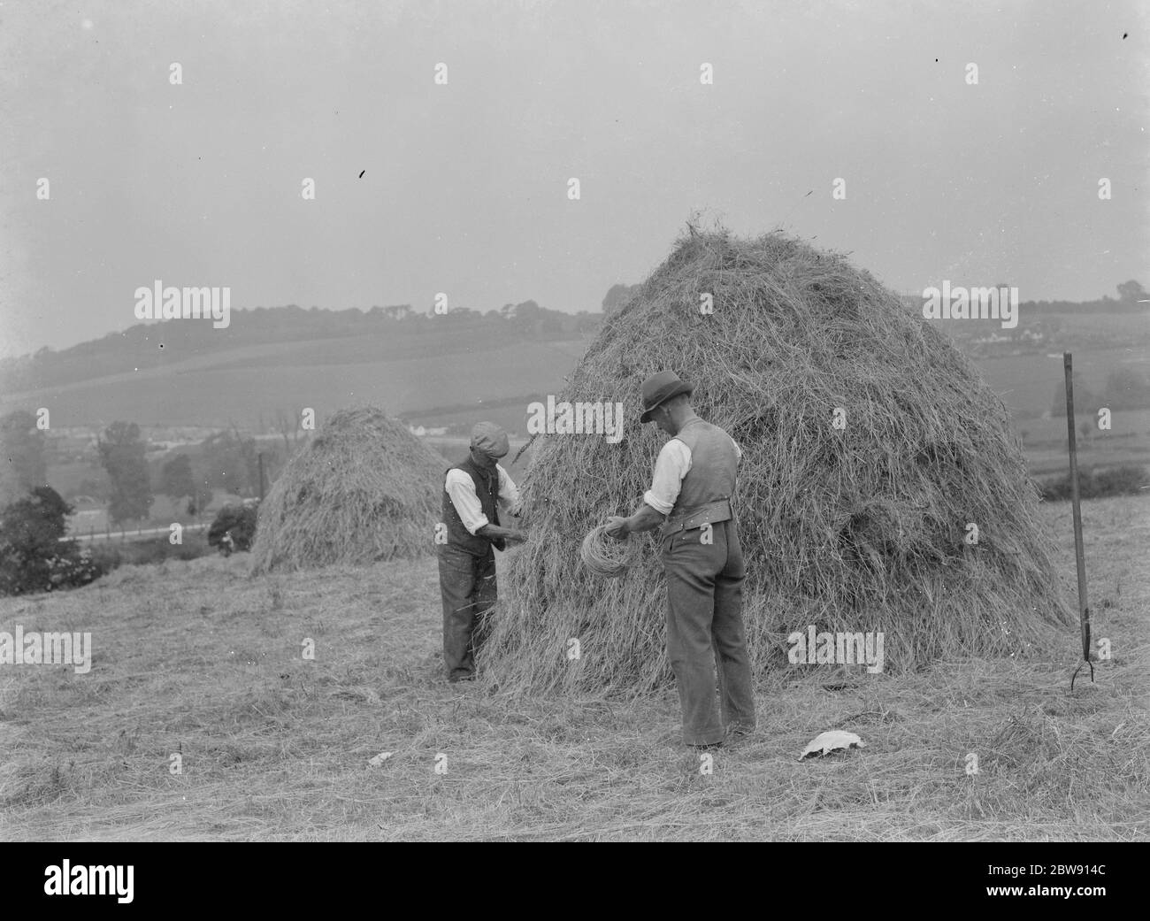 Les agriculteurs usant des méthodes de fabrication de la haymace dans un Farninham , Kent . 1937 Banque D'Images