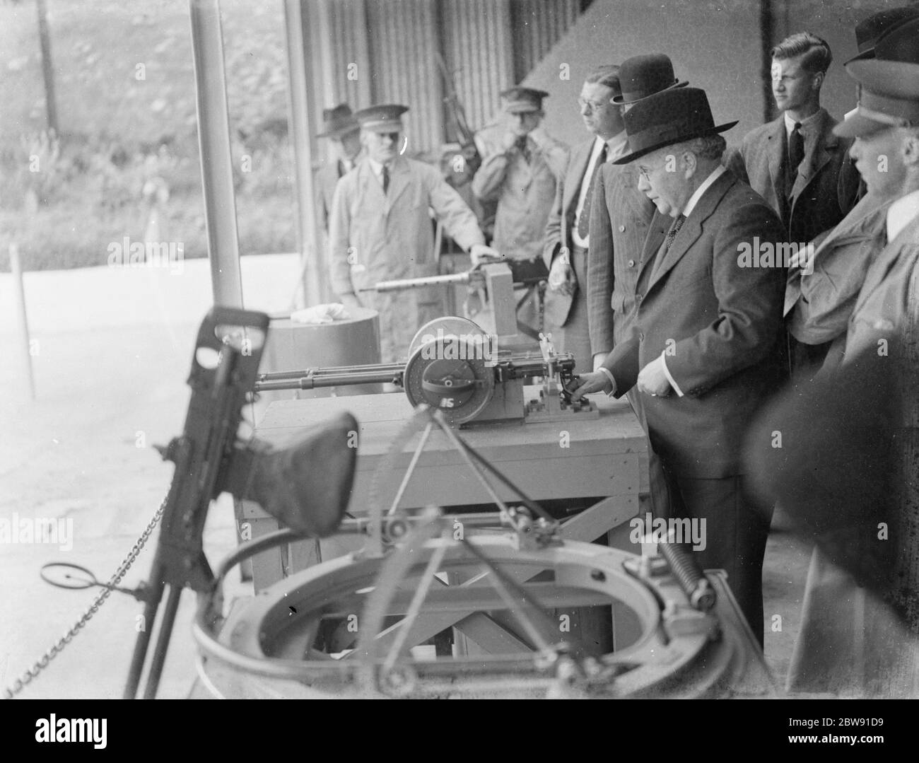 Sir Howard Kingsley Wood , secrétaire d'État à l'Air , visite de l'usine Vickers de Crayford , Kent . Sir Kingsley tient la gâchette de la mitrailleuse à double montage K-GO Vickers . 1939 Banque D'Images