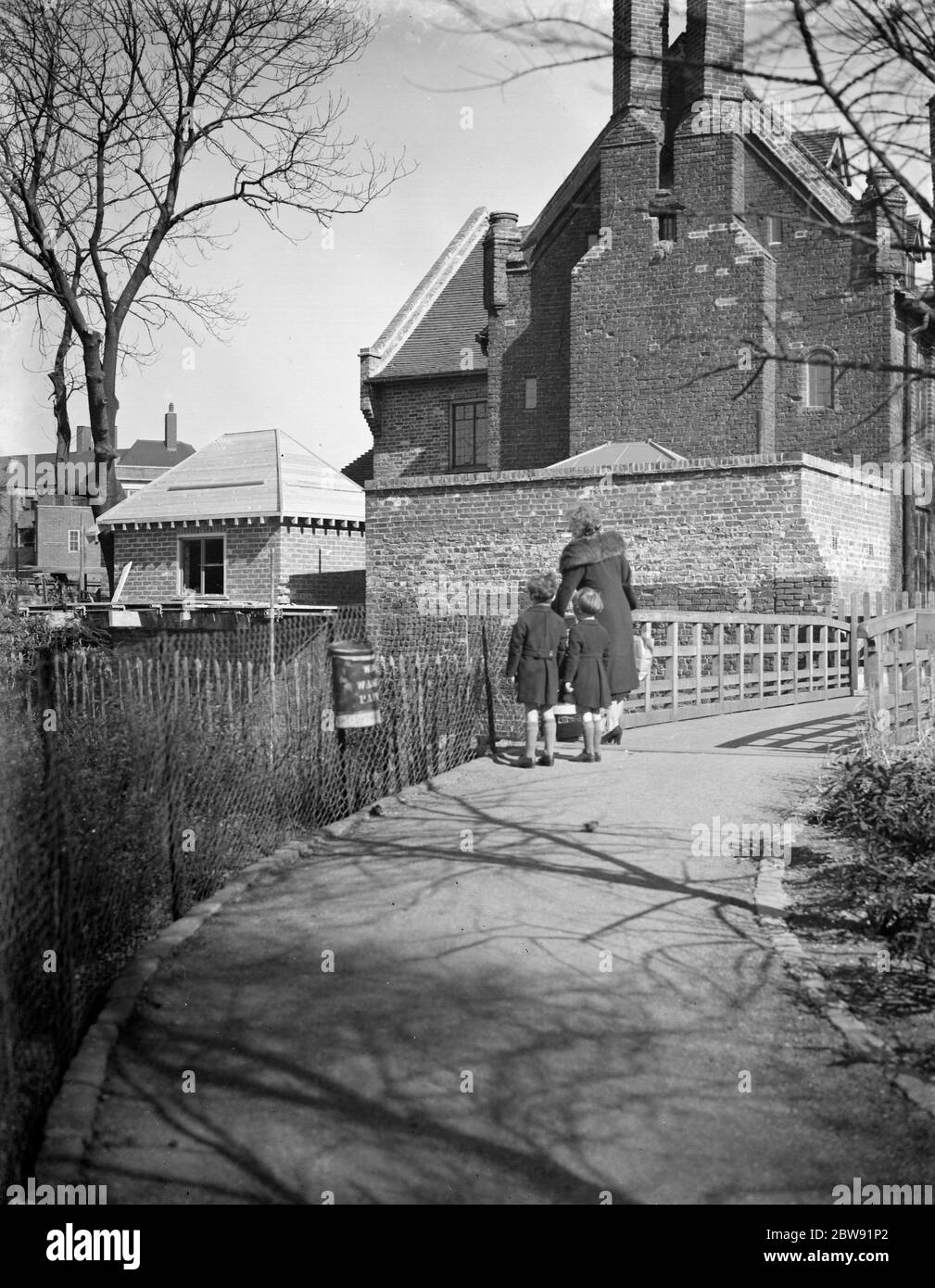 Une mère avec ses enfants admirera le nouvel ajout d'un Tudor Hall à Eltham . 1938 Banque D'Images