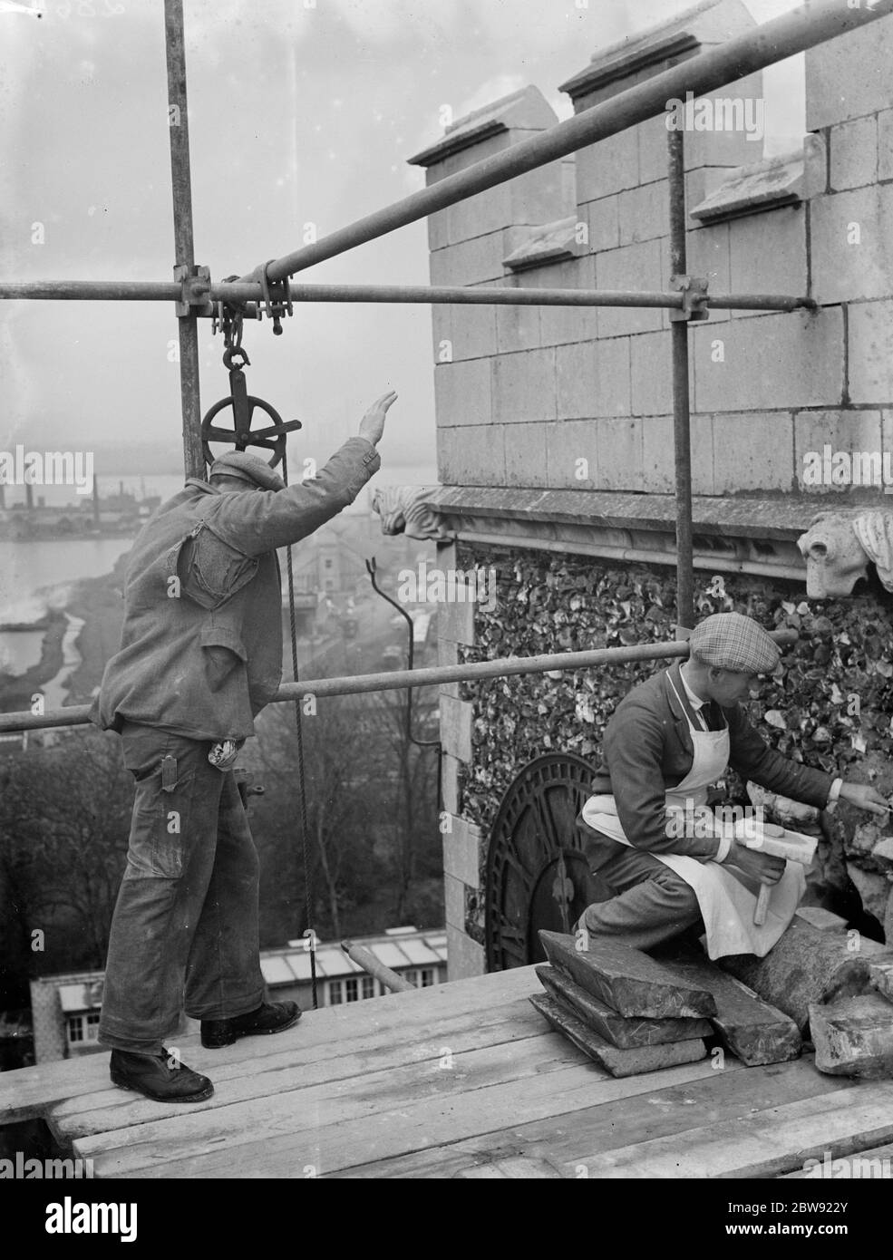 Hommes travaillant sur des rénovations à la maçonnerie en pierre d'une église locale . 1936 Banque D'Images
