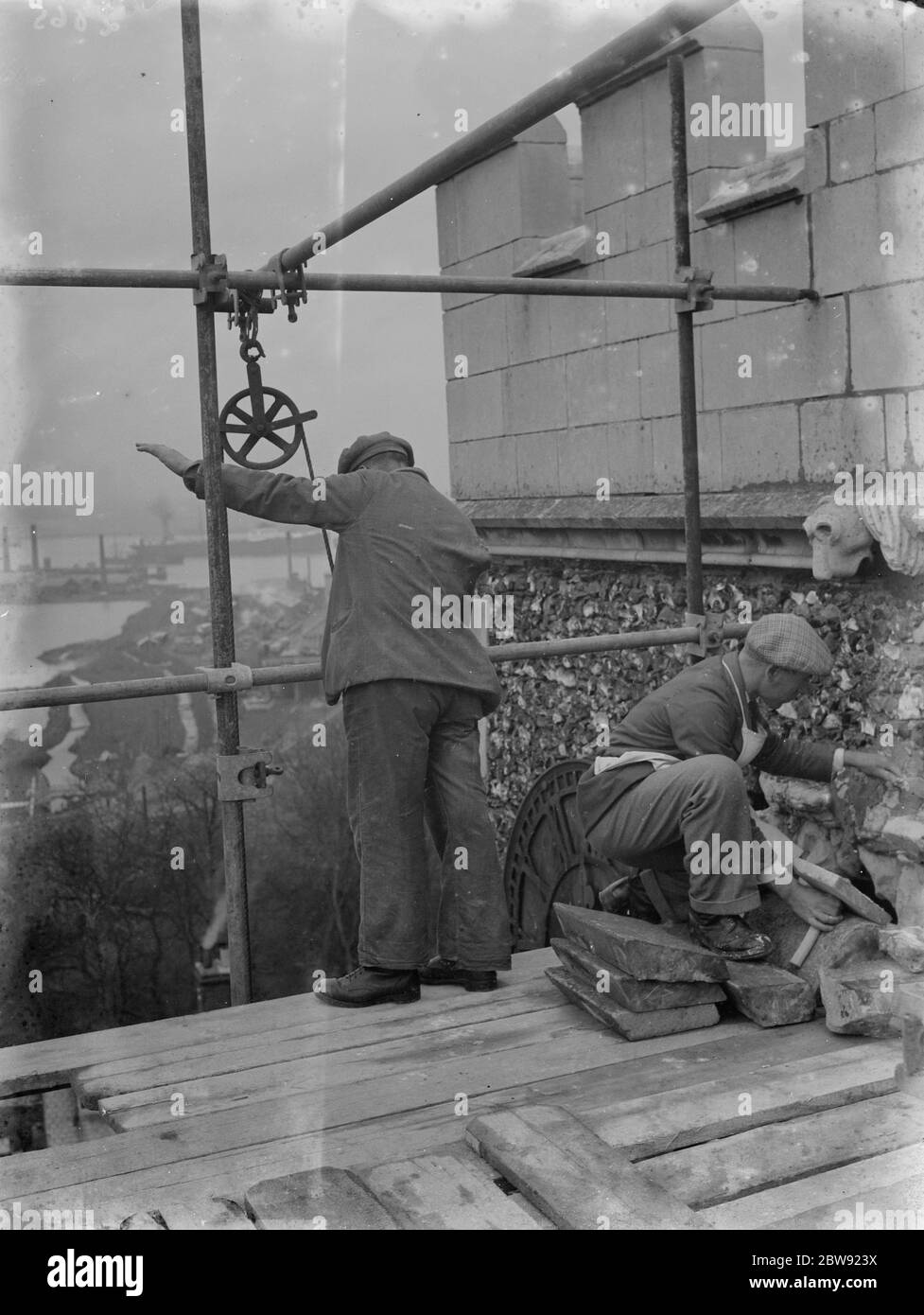 Hommes travaillant sur des rénovations à la maçonnerie en pierre d'une église locale . 1936 Banque D'Images