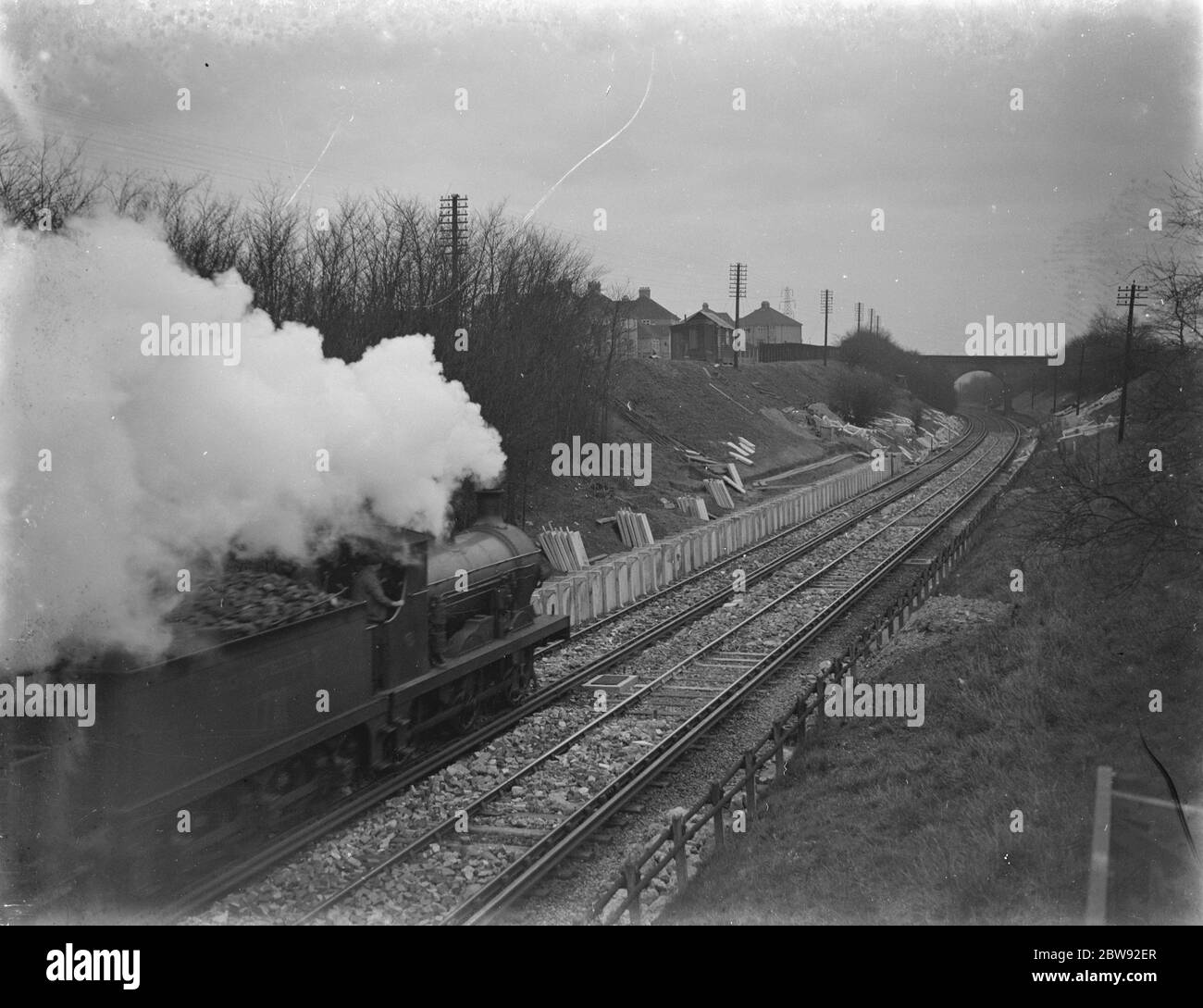 Un train passe devant le site où la gare d'Albany Park est en construction. 1939. Banque D'Images