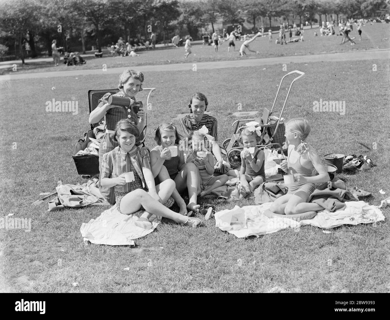 Les voyageurs d'une journée sont venus à la promenade de Gravesend , dans le Kent , pour profiter du temps ensoleillé . Une famille a un pique-nique . 1939 Banque D'Images