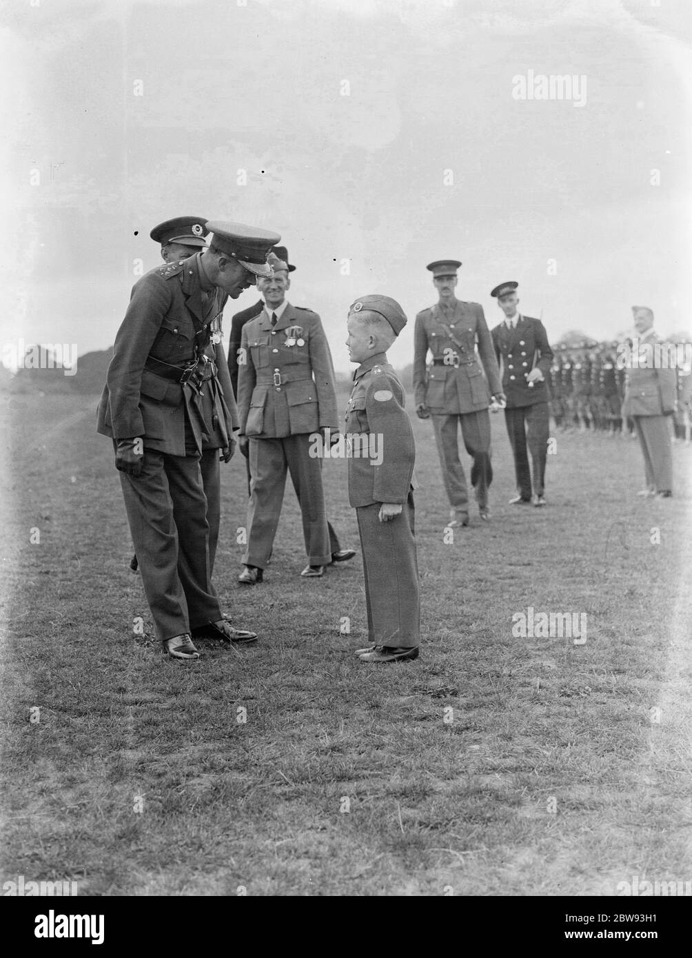 Comme les cadets de l'air sont à l'attention , l'officier s'arrête pour discuter avec la mascotte des unités . 1939 Banque D'Images