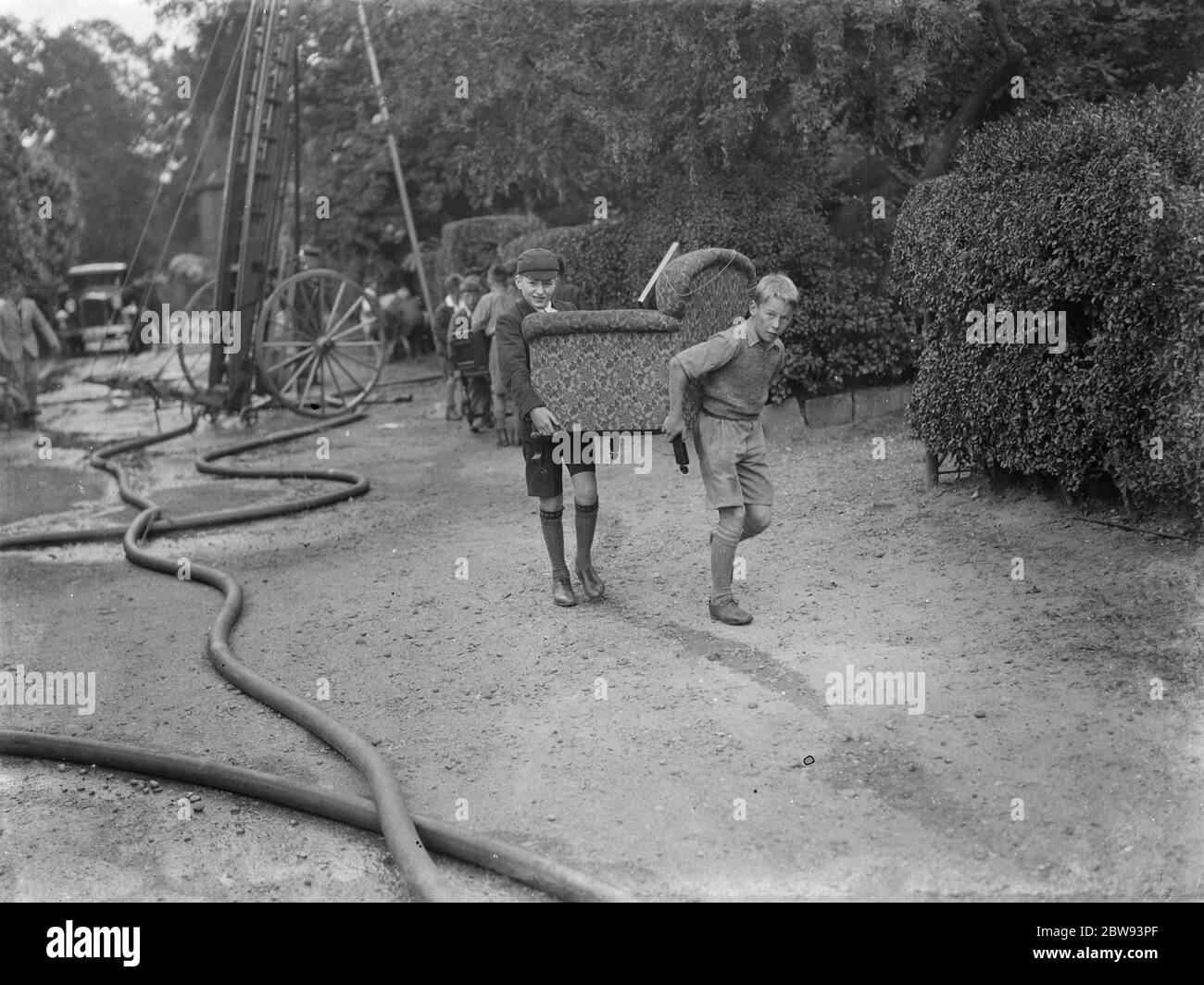 Un incendie à Chislehurst Ampthill . Les locaux aident à essayer de récupérer les meubles de l'épave . 1939 Banque D'Images