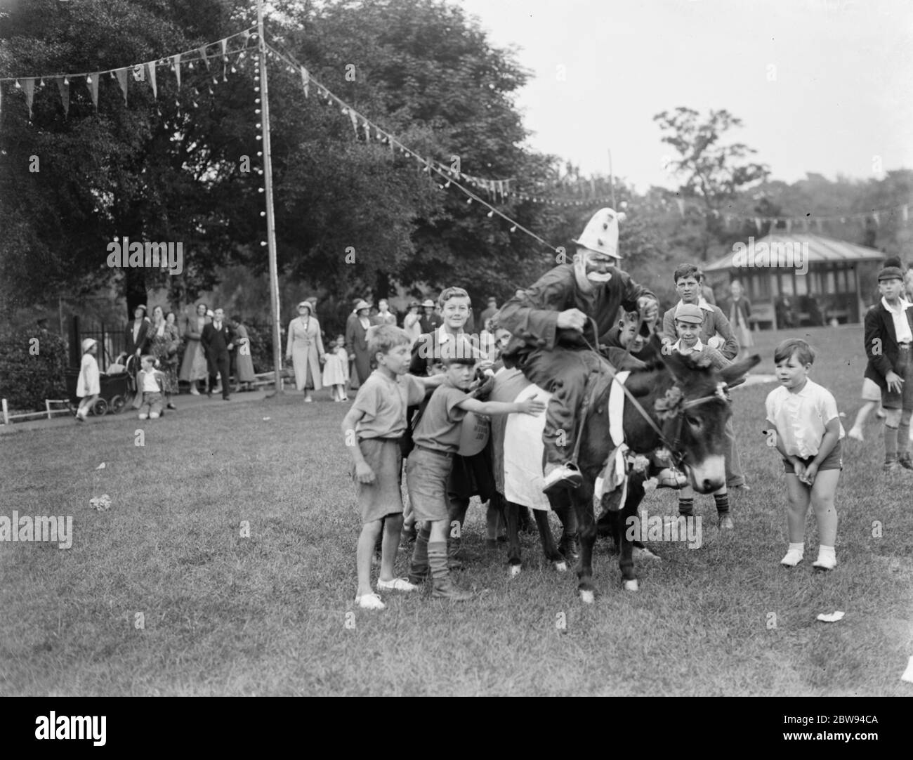Un clown fait un donkey au carnaval de Dartford dans le Kent . 1937 Banque D'Images
