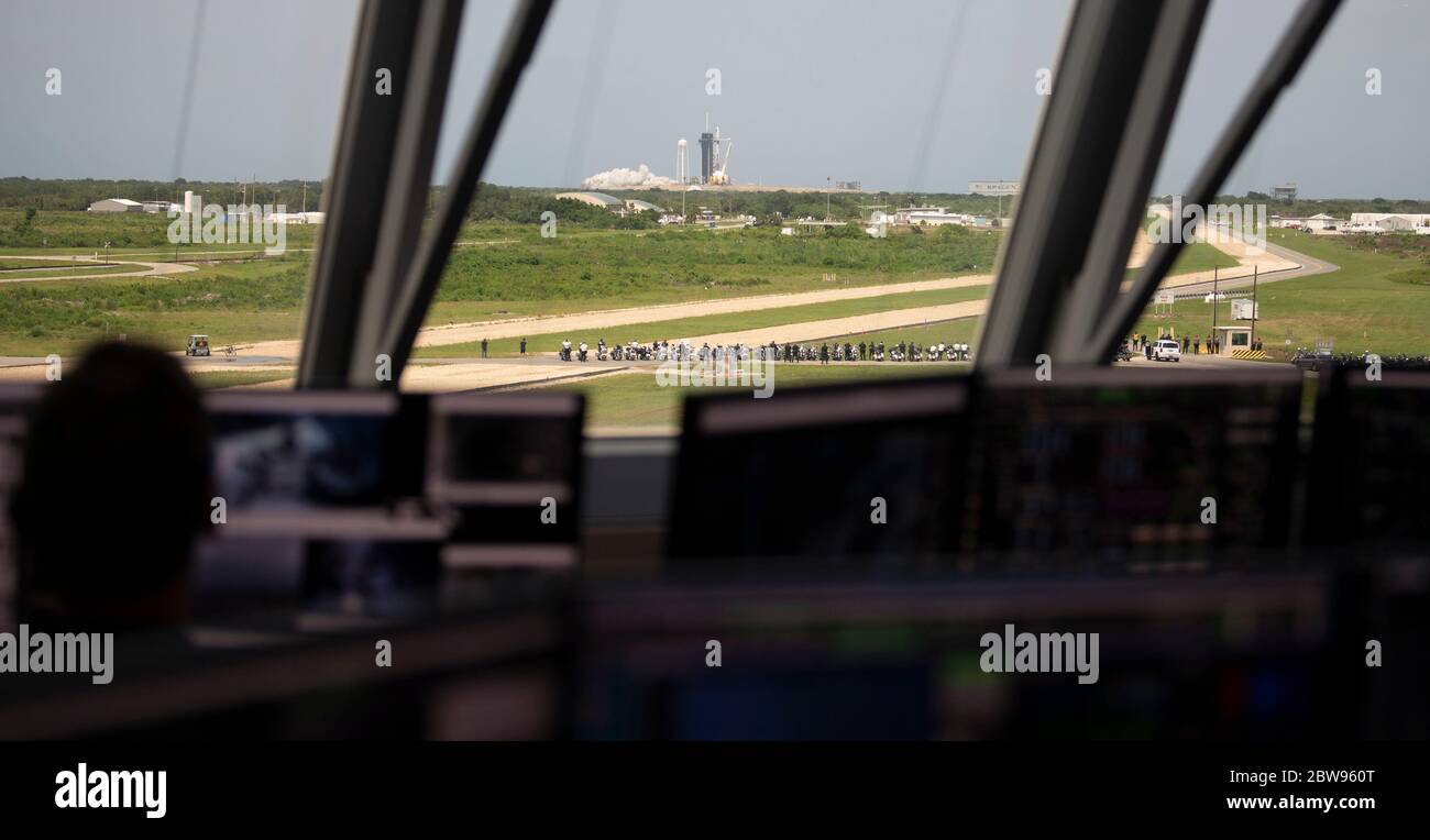 Dans cette photo publiée par la National Aeronautics and Space Administration (NASA), vue par les fenêtres de la salle de tir quatre du Launch Control Center, Une fusée SpaceX Falcon 9 transportant le vaisseau spatial Crew Dragon de la société est lancée à partir du complexe de lancement 39A, dans le cadre de la mission SpaceX Demo-2 de la NASA à destination de la Station spatiale internationale, avec les astronautes de la NASA Robert Behnken et Douglas Hurley à bord, le samedi 30 mai 2020, au Kennedy Space Center de la NASA en Floride. La mission Demo-2 est le premier lancement avec les astronautes de l'engin spatial SpaceX Crew Dragon et de la fusée Falcon 9 vers le Spa International Banque D'Images