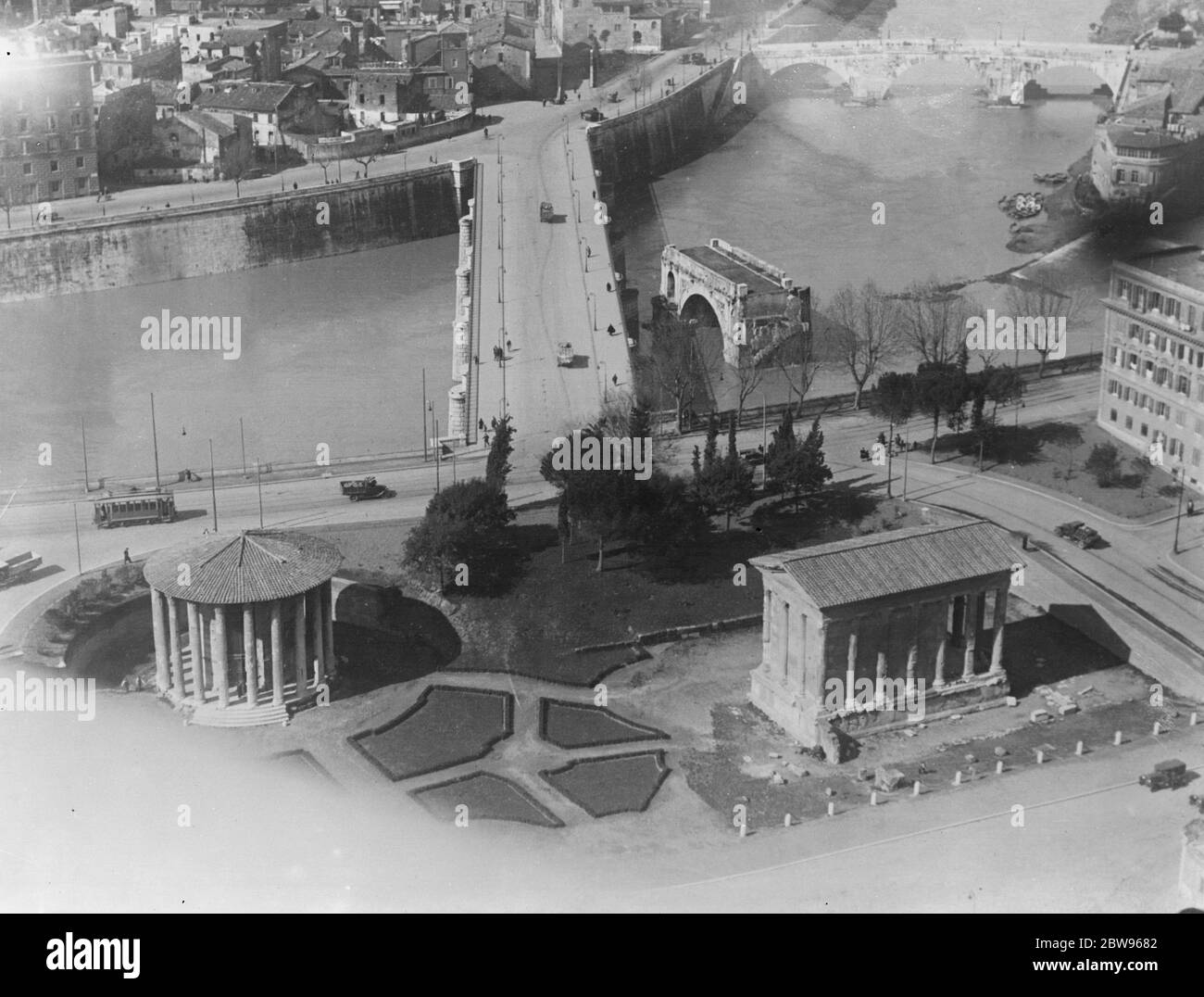 Le visage changeant de Rome . Sous le régime de fer de Mussolini, de nombreuses améliorations publiques sont en cours dans les anciens bâtiments de Rome , rénovés et aménagés dans les jardins publics . Une vue de certaines des améliorations de l'air montrant le nouveau pont Tibur avec les ruines de l'ancien Ponte Rotto , le pont immortalisé par Horatio Cocles , le héros romain légendaire de Lord Macaulay , Qui a glorieusement tenu ce pont avec deux camarades contre l'Armée Etrusque au sixième siècle jusqu'à ce que les citoyens le tailler et ainsi sauvé Rome . Sur la gauche se trouve le Temple de Vesta , la Déesse du coeur Banque D'Images