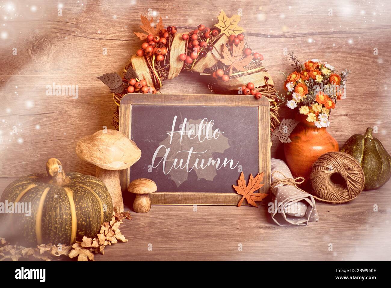 Décorations rustiques d'automne, texte « Hello Autumn » sur un tableau noir. Automne naturel récolte de Thanksgiving. Feuilles d'automne, couronne décorative, baies et bois Banque D'Images