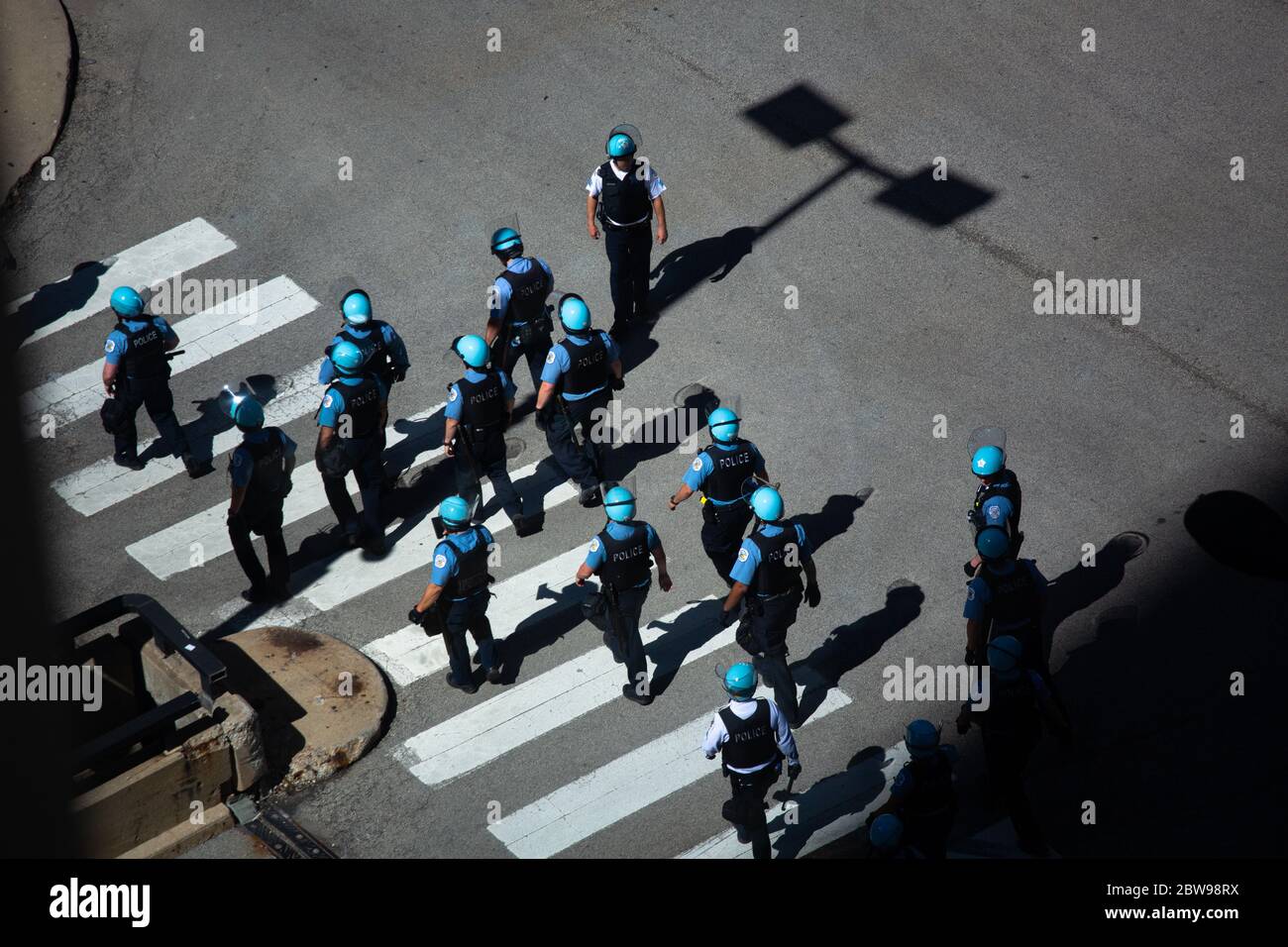 Un grand groupe de policiers de Chicago avec des casques bleu clair marchant à travers un passage dans le centre de Chicago, il avant les manifestations de 2020 Banque D'Images