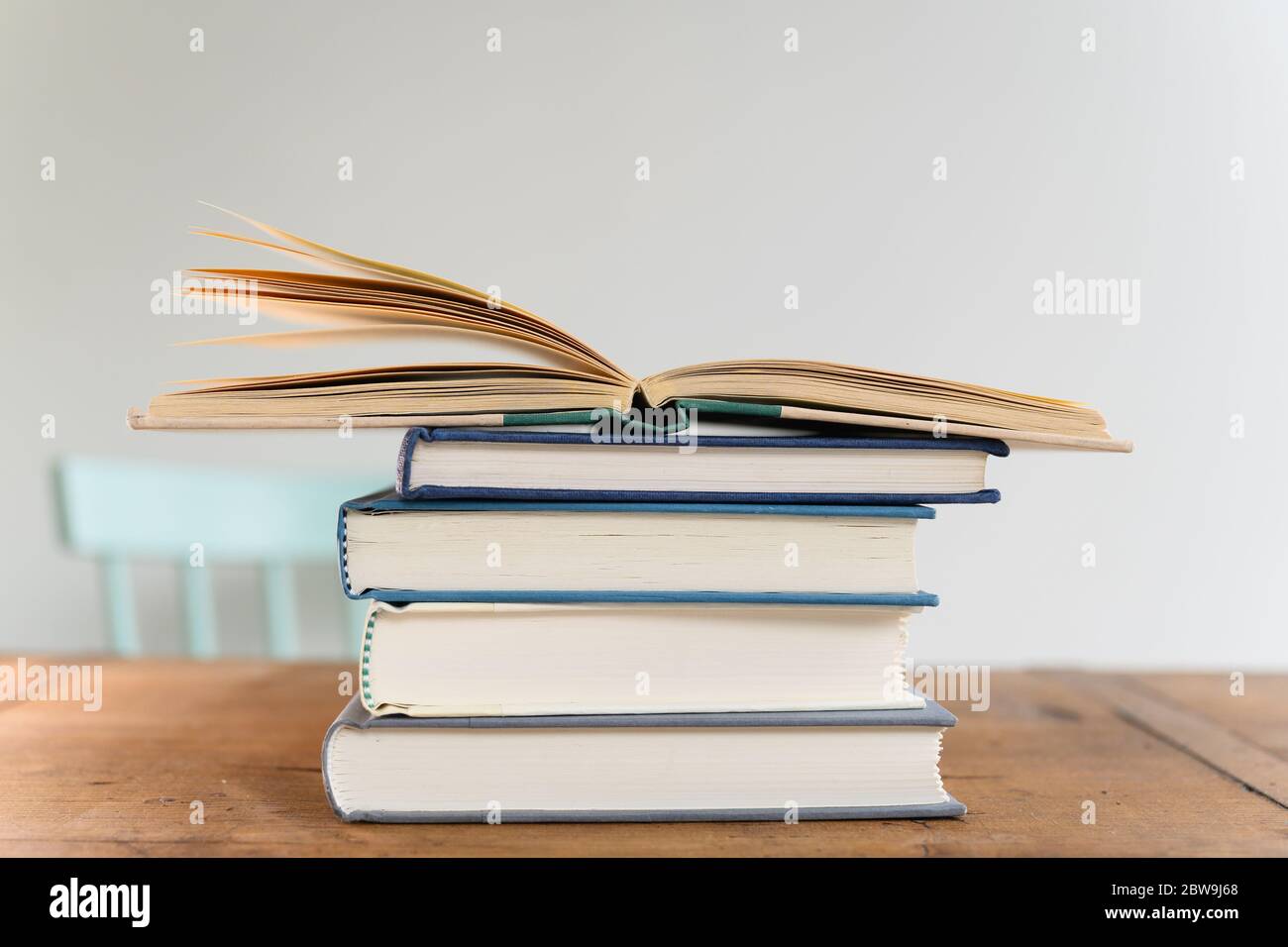 Livre ouvert sur le dessus de la pile de livres sur le bureau Banque D'Images