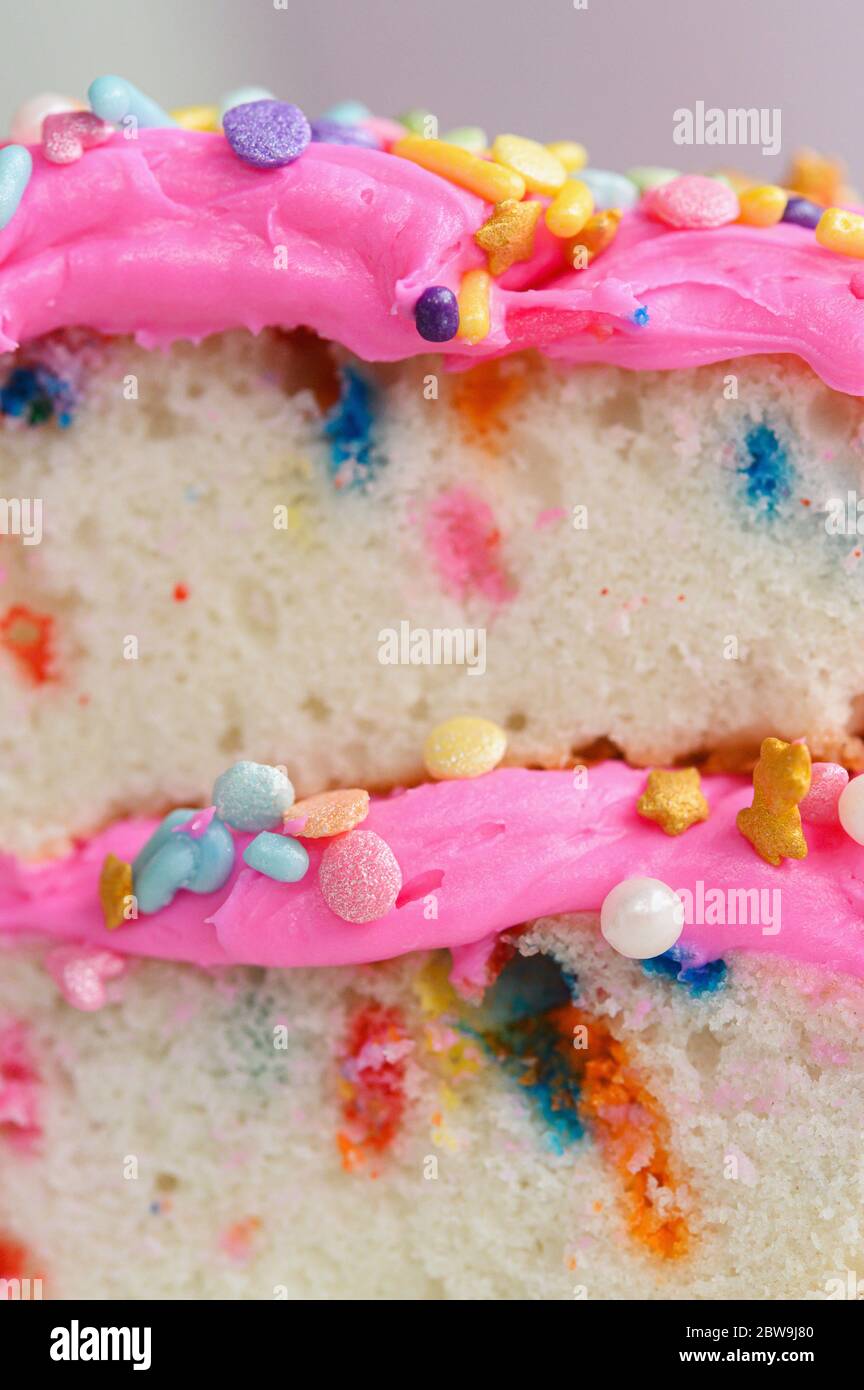 Saupoudrer de couleur sur la glaçage rose des gâteaux Banque D'Images