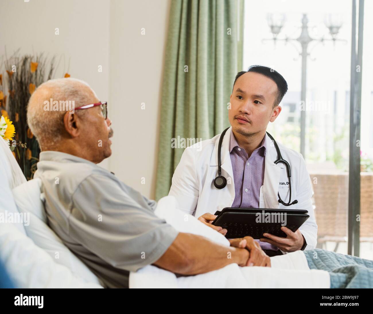 Médecin parlant à l'homme âgé en maison de soins infirmiers Banque D'Images