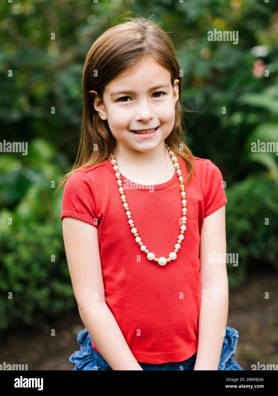 USA, Californie, Orange County, Portrait de fille souriante (6-7) portant un collier de perles Banque D'Images