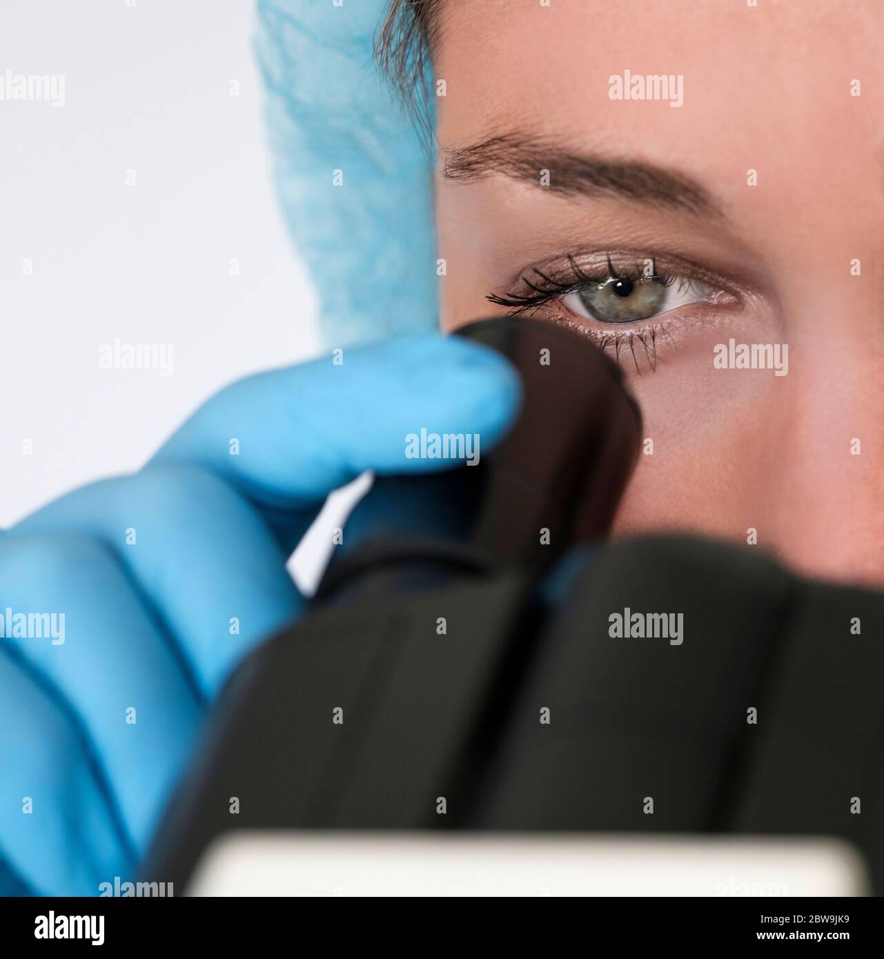 Technicien de laboratoire regardant au microscope Banque D'Images