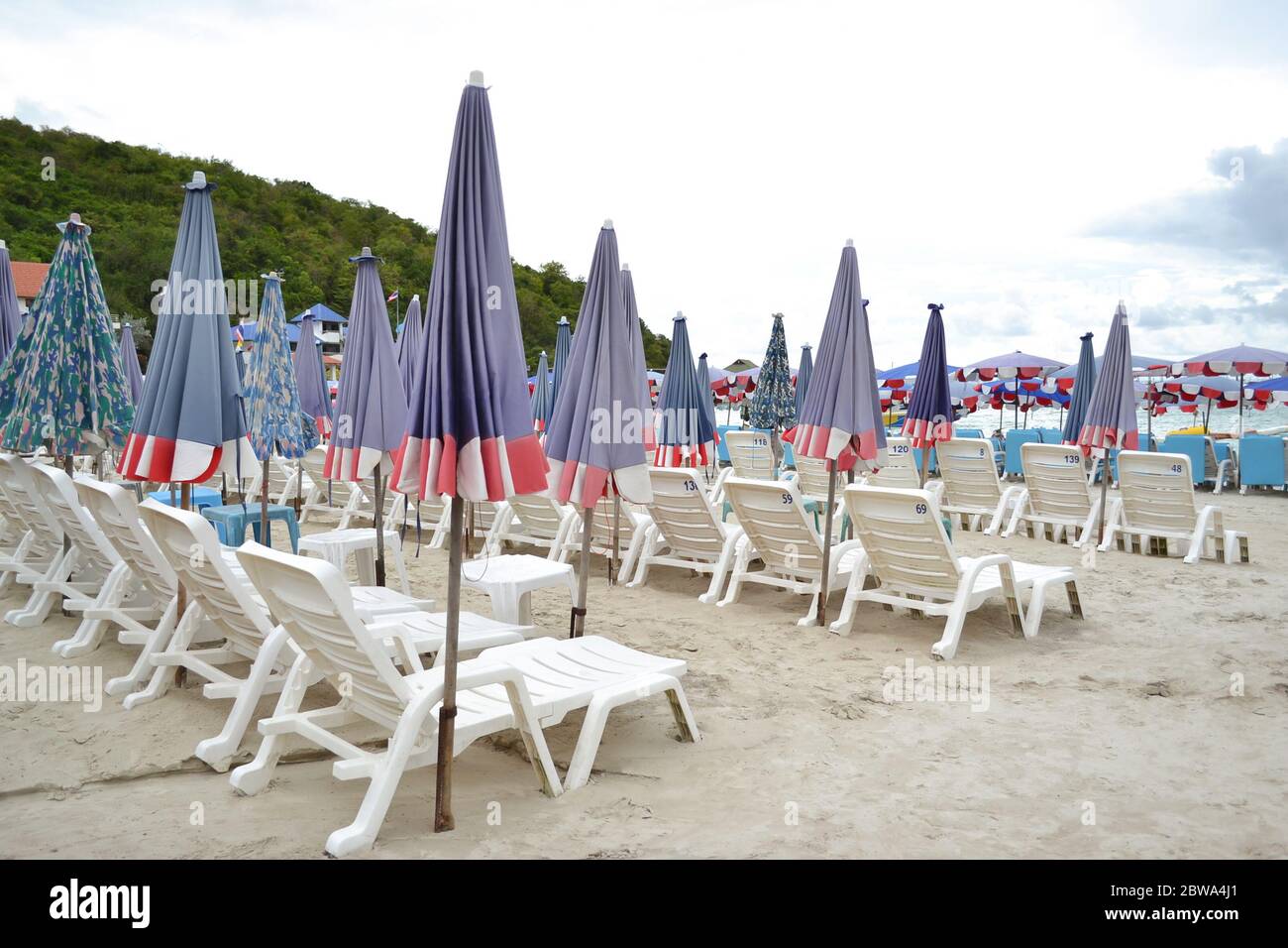 Chaises de plage ou chaises longues et parasols sur la plage de sable de l'île de Koh Larn, Pattaya, Thaïlande. À utiliser pour un voyageur pour se détendre sur un aspirateur parfait Banque D'Images