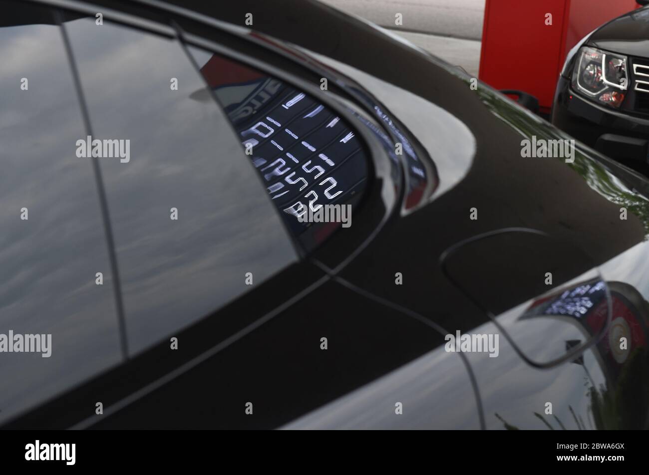 Oberpfaffenhofen, Allemagne. 30 mai 2020. Un pare-brise de voiture hybride Porsche reflète un tableau de bord qui affiche les prix de l'essence dans une station-service. Credit: Felix Hörhager/dpa/Alay Live News Banque D'Images