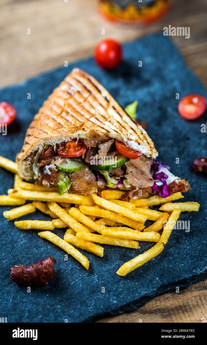 Faire don de kebab avec des légumes et des frites sur une table en bois Banque D'Images