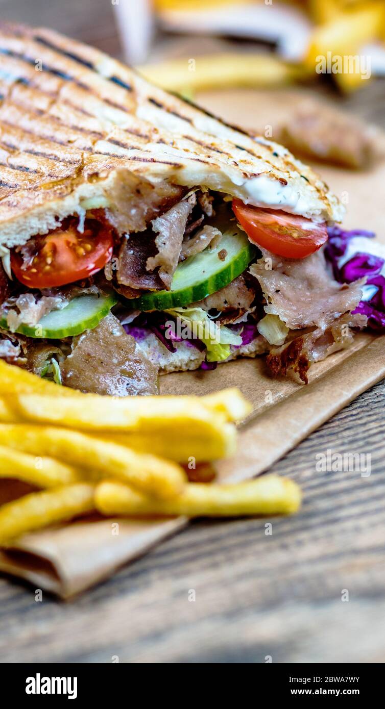 Faire don de kebab avec des légumes et des frites sur une table en bois Banque D'Images