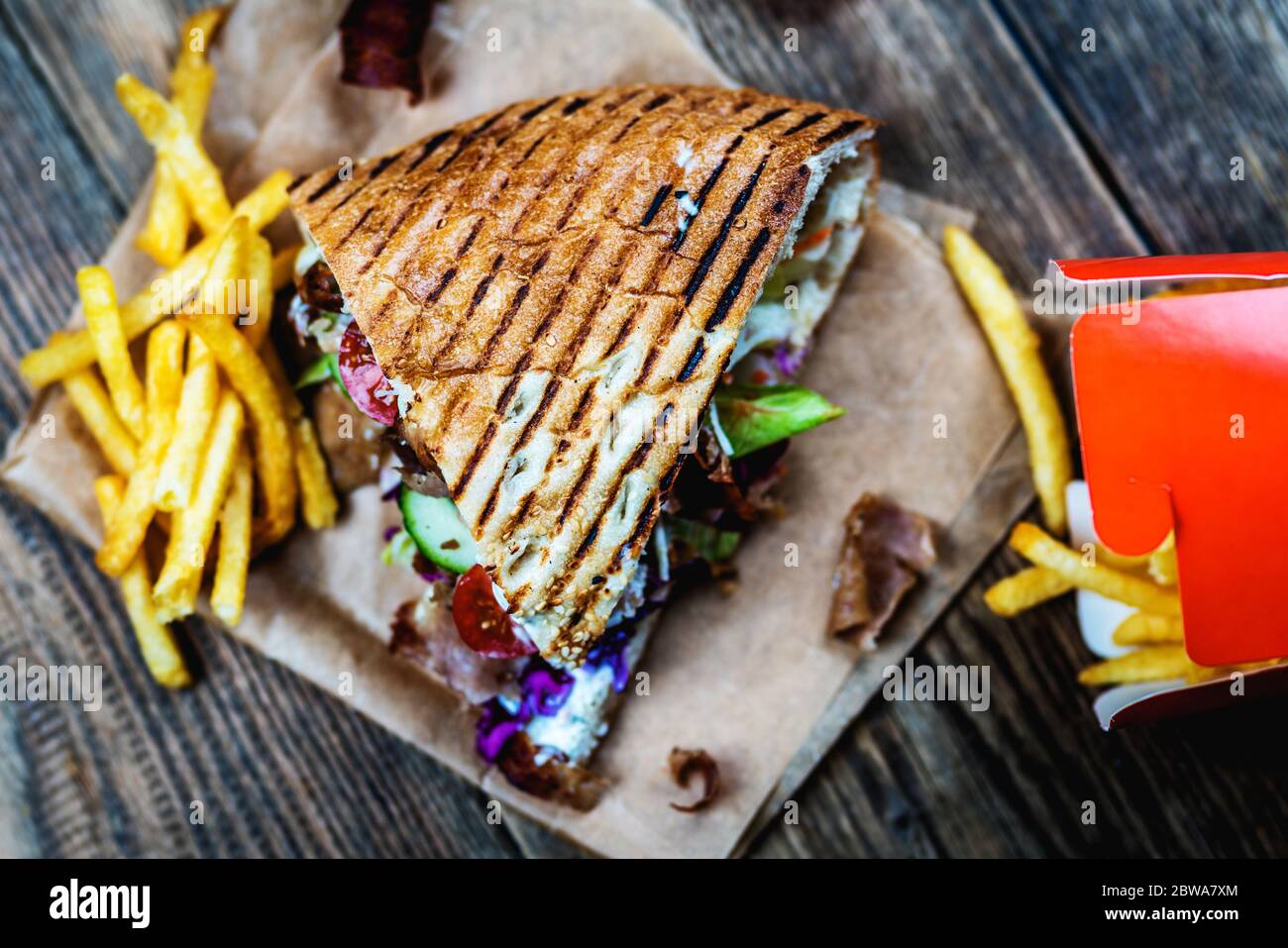 Faire don de kebab avec des légumes et des frites sur une table en bois Banque D'Images
