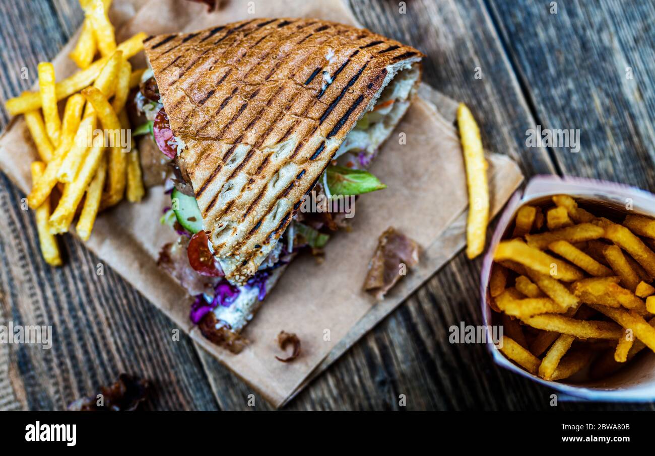 Faire don de kebab avec des légumes et des frites sur une table en bois Banque D'Images